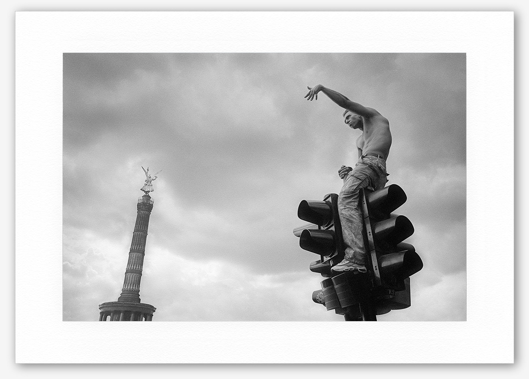 Steve Hanson photography. Man on top of a traffic light, Berlin, Germany.