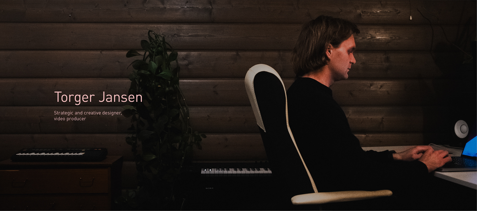 Side profile of T2 working on a laptop. Text: Torger Jansen. Strategic and creative designer, video producer.