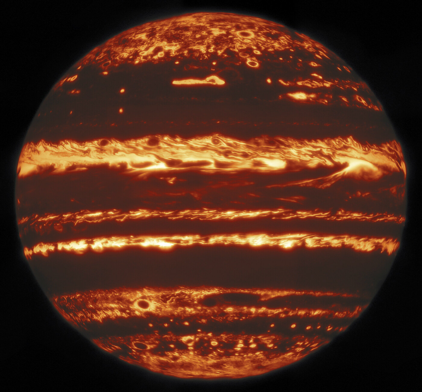 This image showing the entire disk of Jupiter in infrared light was compiled from a mosaic of nine separate pointings observed by the international Gemini Observatory, a program of NSF’s NOIRLab on 29 May 2019. From a “lucky imaging” set of 38 exposures taken at each pointing, the research team selected the sharpest 10%, combining them to image one ninth of Jupiter’s disk. Stacks of exposures at the nine pointings were then combined to make one clear, global view of the planet. Even though it only takes a few seconds for Gemini to create each image in a lucky imaging set, completing all 38 exposures in a set can take minutes — long enough for features to rotate noticeably across the disk. In order to compare and combine the images, they are first mapped to their actual latitude and longitude on Jupiter, using the limb, or edge of the disk, as a reference. Once the mosaics are compiled into a full disk, the final images are some of the highest-resolution infrared views of Jupiter ever taken from the ground.  Credit: International Gemini Observatory/NOIRLab/NSF/AURA, M.H. Wong (UC Berkeley) and team  Acknowledgments: Mahdi Zamani