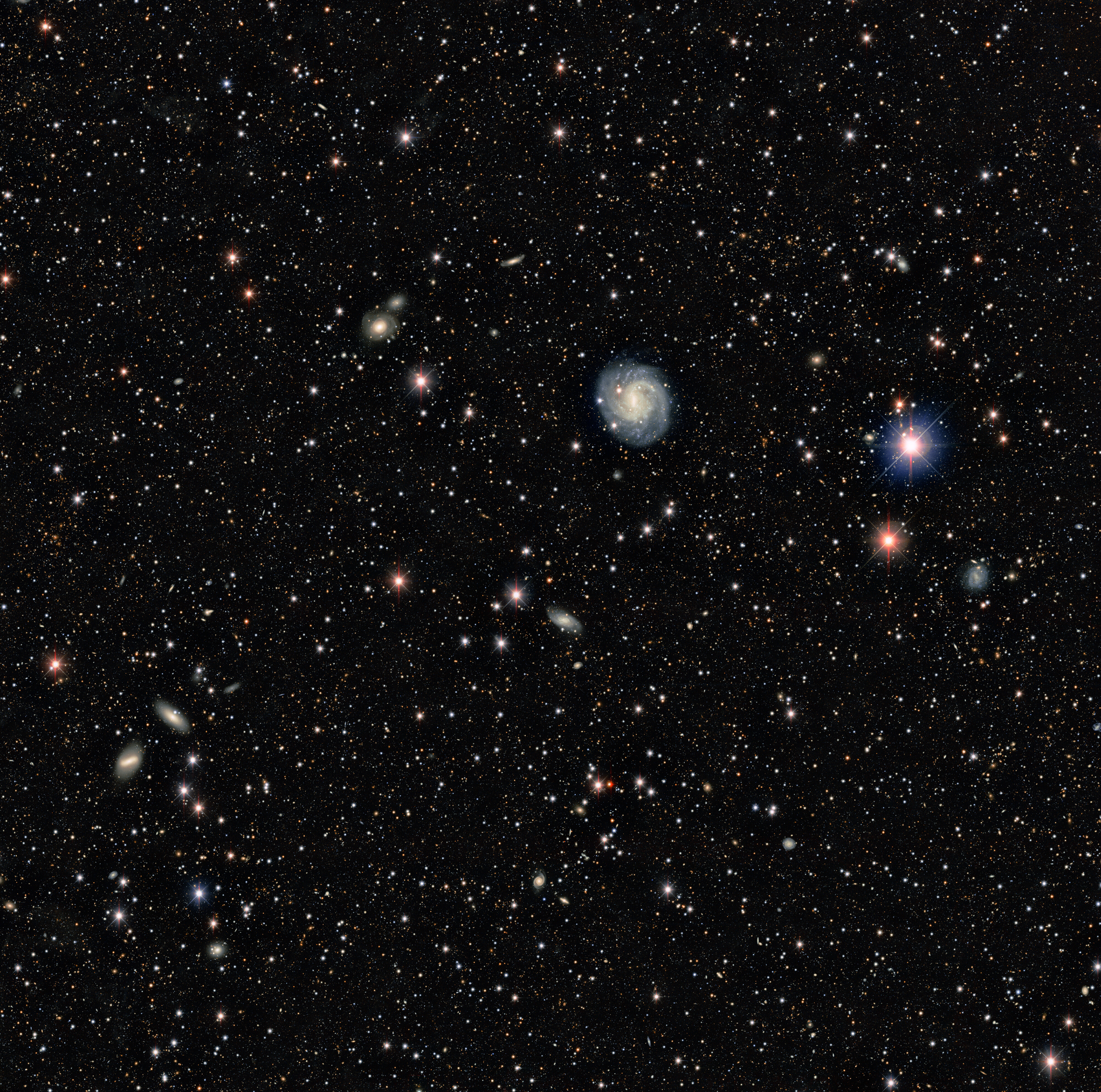 The Dark Energy Camera's 1 millionth exposure. At the time of this exposure DECam was making an of a galaxy cluster. The 1 millionth exposure has been combined with 127 earlier exposures to make this view of the field.  This demonstrates the power of DECam and an archive of a million exposures.  The biggest galaxy in the field is the face-on spiral galaxy ESO 440-11. Several galaxy clusters, thousands of background galaxies and a few handfuls of foreground Milky Way stars can be seen in this “random” image of the sky.   One of the most powerful digital cameras in the world, the Dark Energy Camera was designed specifically for the Dark Energy Survey (DES). It was funded by the Department of Energy (DOE) and was built and tested at DOE's Fermilab.  Credit: Dark Energy Survey/DOE/FNAL/DECam/CTIO/NOIRLab/NSF/AURA  Acknowledgments: T.A. Rector (University of Alaska Anchorage/NSF’s NOIRLab), M. Zamani (NSF’s NOIRLab) & D. de Martin (NSF’s NOIRLab)