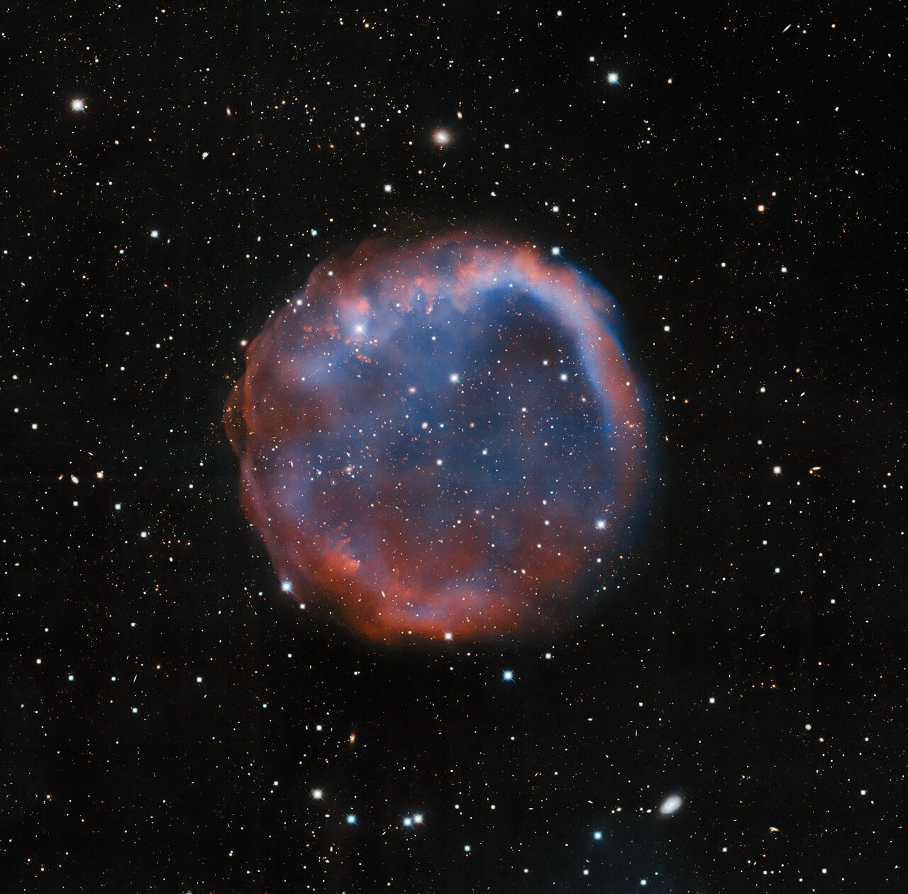 This image, which looks a little like an enormous bubble in space, features a planetary nebula known as EGB 6. It was imaged by the Nicholas U. Mayall 4-meter Telescope at Kitt Peak National Observatory (KPNO), a Program of NSF’s NOIRLab. Planetary nebulae, notoriously, have nothing to do with planets. They form during the dying millennia of intermediate-mass stars, stars with masses between one and eight times the mass of the Sun. “Dying millennia” might sound like a very long time, but compared to the overall lifespan of a star, planetary nebulae are extremely short-lived. Towards the end of their life cycle, intermediate-mass stars enter the red giant phase, during which fusion reactions temporarily reignite in a dying star’s core. Layers of gas, shed or ejected during the red giant phase, absorb vast amounts of energy and create the gorgeous phenomena known as planetary nebulae. The dying millenia only last about 20,000 years, a mere blink of an eye when you consider that intermediate-mass stars shine steadily for between 30 million to 10 billion years (depending on their mass) before they die.  Credit: KPNO/NOIRLab/NSF/AURA Image processing: T.A. Rector (University of Alaska Anchorage/NSF’s NOIRLab), M. Zamani (NSF’s NOIRLab) & D. de Martin (NSF’s NOIRLab)