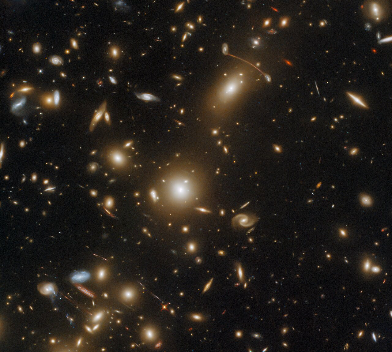 The massive galaxy cluster Abell 1351 is captured in this image by the NASA/ESA Hubble Space Telescope’s Wide Field Camera 3 and Advanced Camera for Surveys. This galaxy cluster lies in the constellation Ursa Major in the northern hemisphere.  This image is filled with streaks of light, which are actually the images of distant galaxies. The streaks are the result of gravitational lensing, an astrophysical phenomenon that occurs when a massive celestial body such as a galaxy cluster distorts spacetime sufficiently strongly to affect the path of light passing through it — almost as if the light were passing through a gigantic lens. Gravitational lensing comes in two varieties — strong and weak — and both can give astronomers an insight into the distribution of mass within a lensing galaxy cluster such as Abell 1351.  This observation is part of an astronomical album comprising snapshots of some of the most massive galaxy clusters. This menagerie of massive clusters demonstrates interesting astrophysical phenomena such as strong gravitational lensing, as well as showcasing spectacular examples of violent galaxy evolution. To obtain this astronomical album, astronomers proposed a Snapshot Program to be slotted into Hubble’s packed observing schedule. These Snapshot Programs are lists of separate, relatively short exposures which can fit into gaps between longer Hubble observations. Having a large pool of Snapshot candidates to dip into allows Hubble to use every second of observing time possible and to maximise the scientific output of the observatory.  Links Video of An Snapshot of a Massive Cluster Credit: ESA/Hubble & NASA, H. Ebeling Acknowledgement: L. Shatz