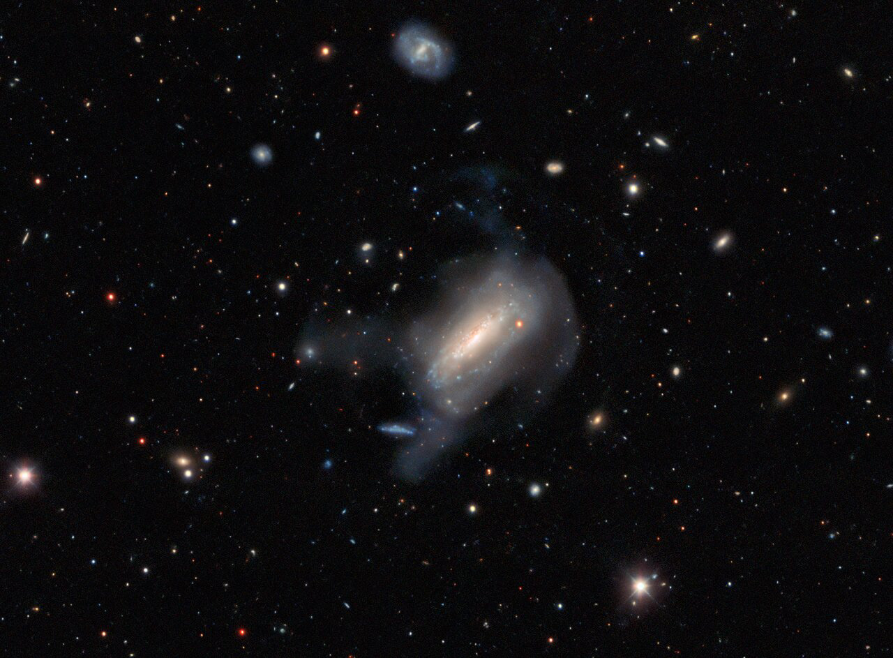 The constellation Coma Berenices hosts the galaxy NGC 4495 among myriad other astronomical objects. This galaxy has a tumultuous history: several supernovae have been recorded over the years, including the three named 1994S, 2010lo, and 2011ca. This last burst of energy from a dying star can be triggered by a number of different processes. 1994S, for example, was triggered by interactions between a white dwarf and another star, which reignited the core of the stellar remnant — a Type Ia supernova. 2011ca on the other hand is a Type Ic supernova, triggered by the core collapse of a single massive star.  This image was captured by the DOE-built Dark Energy Camera (DECam) on the Víctor M. Blanco 4-meter Telescope at Cerro Tololo Inter-American Observatory (CTIO) as part of the DESI Legacy Imaging Surveys. The DESI Legacy Imaging Surveys were conducted to identify targets for the Dark Energy Spectroscopic Instrument (DESI) operations. These surveys comprise a unique blend of three projects that have observed a third of the night sky. DESI is an international science collaboration managed by the US Department of Energy's (DOE) Lawrence Berkeley National Laboratory with primary funding for construction and operations from DOE’s Office of Science.  Credit: Dark Energy Survey/DOE/FNAL/DECam/CTIO/NOIRLab/NSF/AURA  Image processing: Travis Rector (University of Alaska Anchorage/NSF’s NOIRLab), Jen Miller (Gemini Observatory/NSF’s NOIRLab), Mahdi Zamani & Davide de Martin (NSF’s NOIRLab)