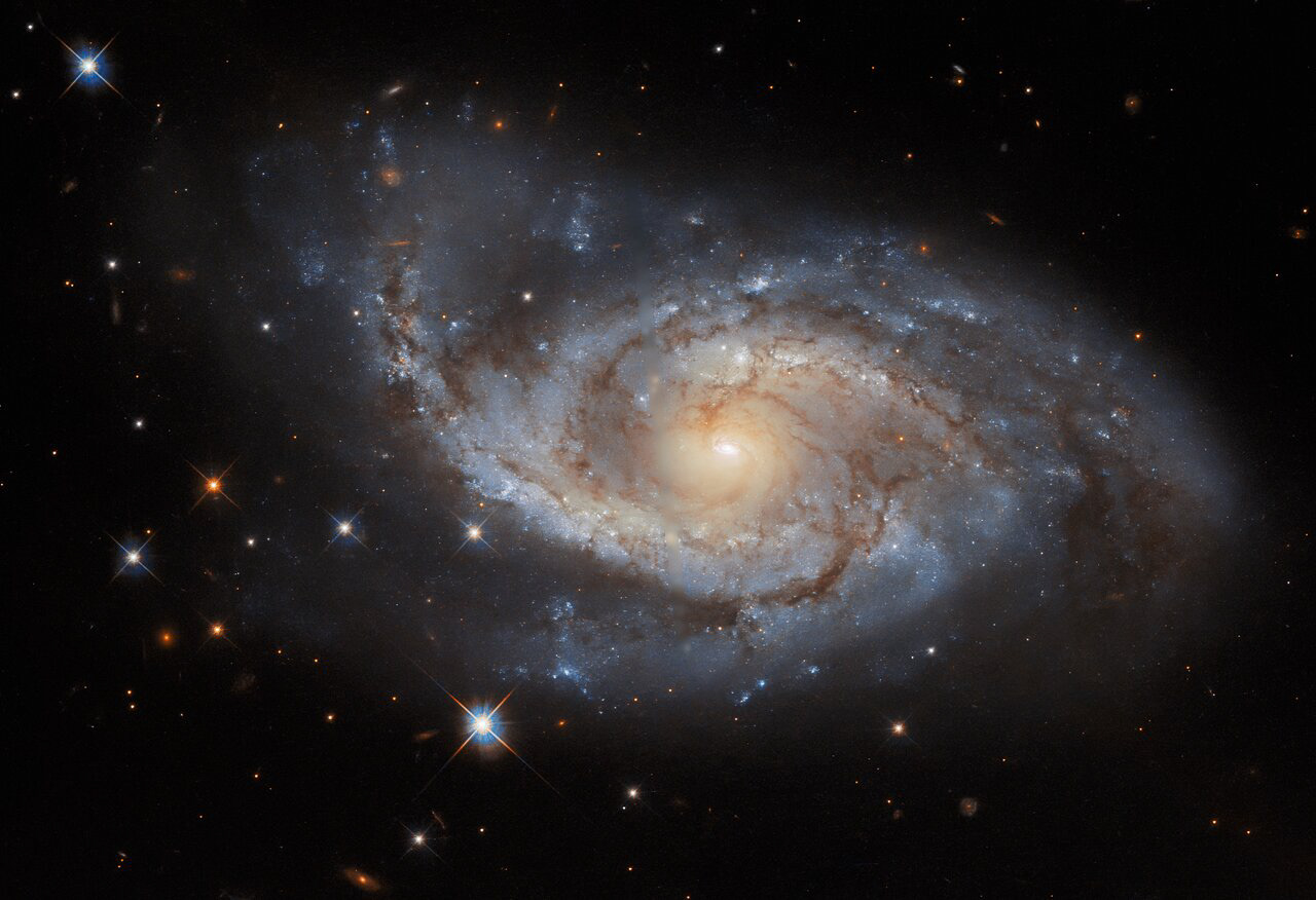 The spiral arms of the galaxy NGC 3318 are lazily draped across this image from the NASA/ESA Hubble Space Telescope. This spiral galaxy lies in the constellation Vela and is roughly 115 million light-years away from Earth. Vela was originally part of a far larger constellation, known as Argo Navis after the fabled ship Argo from Greek mythology, but this unwieldy constellation proved to be impractically large. Argo Navis was split into three separate parts called Carina, Puppis, and Vela — each named after part of the Argo. As befits a galaxy in a nautically inspired constellation, the outer edges of NGC 3318 almost resemble a ship’s sails billowing in a gentle breeze.  Credit: ESA/Hubble & NASA, ESO, R. J. Foley Acknowledgement: R. Colombari