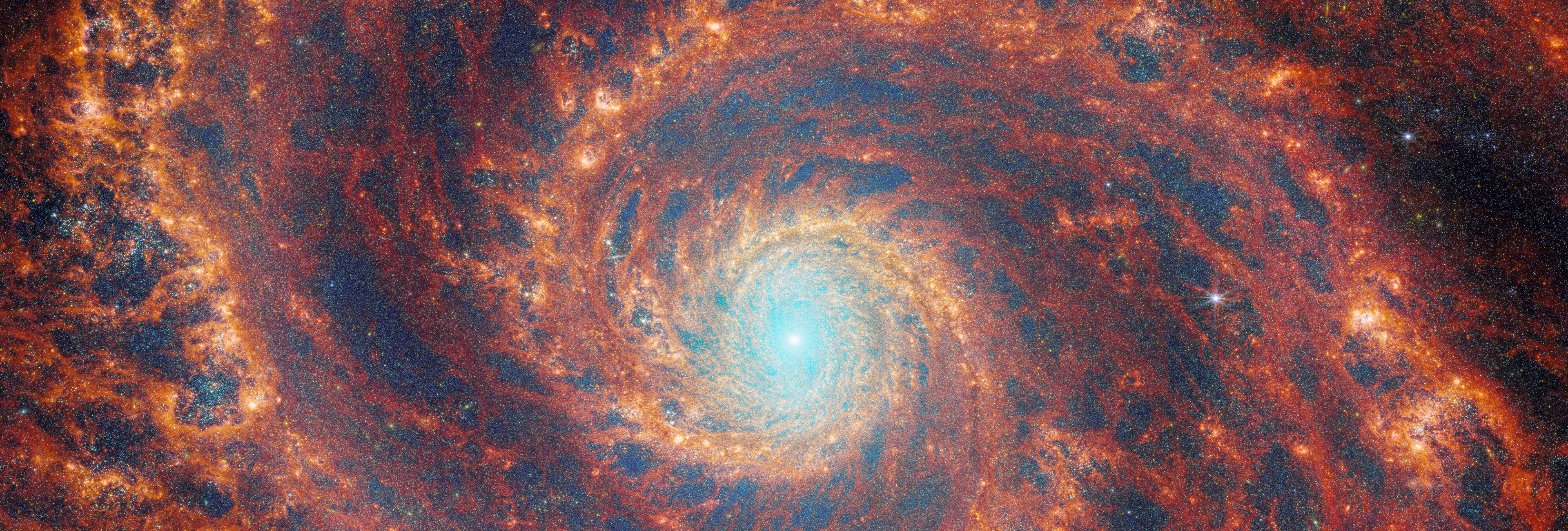 The graceful winding arms of the grand-design spiral galaxy M51 stretch across this image from the NASA/ESA/CSA James Webb Space Telescope.  Credit: ESA/Webb, NASA & CSA, A. Adamo (Stockholm University) and the FEAST JWST team