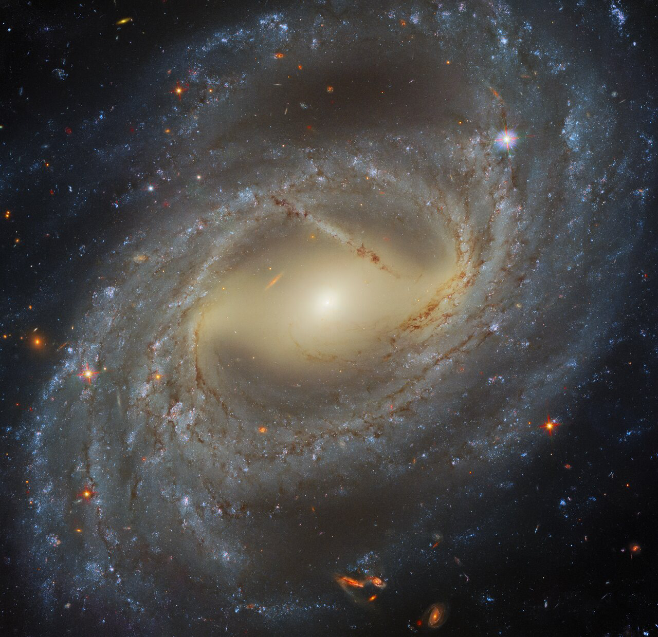 This stellar whirlpool is a spiral galaxy named NCG 7329, which has been imaged by Hubble’s Wide Field Camera 3 (WFC3). Creating a colourful image such as this one using a telescope such as Hubble is not as straightforward as pointing and clicking a camera. Commercial cameras will typically try to collect as much light of all visible wavelengths as they can, in order to create the most vibrant images possible. In contrast, raw images collected by Hubble are always monochromatic, because astronomers typically want to capture very specific ranges of wavelengths of light at any time, in order to do the best, most accurate science possible. In order to control which wavelengths of light will be collected, Hubble’s cameras are equipped with a wide variety of filters, which only allow certain wavelengths of light to reach the cameras’ CCDs (a CCD is a camera’s light sensor — phone cameras also have CCDs!).   How are the colourful Hubble images possible given that the raw Hubble images are monochromatic? This is accomplished by combining multiple different observations of the same object, obtained using different filters. This image, for example, was processed from Hubble observations made using four different filters, each of which spans a different region of the light spectrum, from the ultraviolet to optical and infrared. Specialised image processors and artists can make informed judgements about which optical colours best correspond to each filter used. They can then colour the images taken using that filter accordingly. Finally, the images taken with different filters are stacked together, and voila! The colourful image of a distant galaxy is complete, with colours as representative of reality as possible.  Credit: ESA/Hubble & NASA, A. Riess et al.