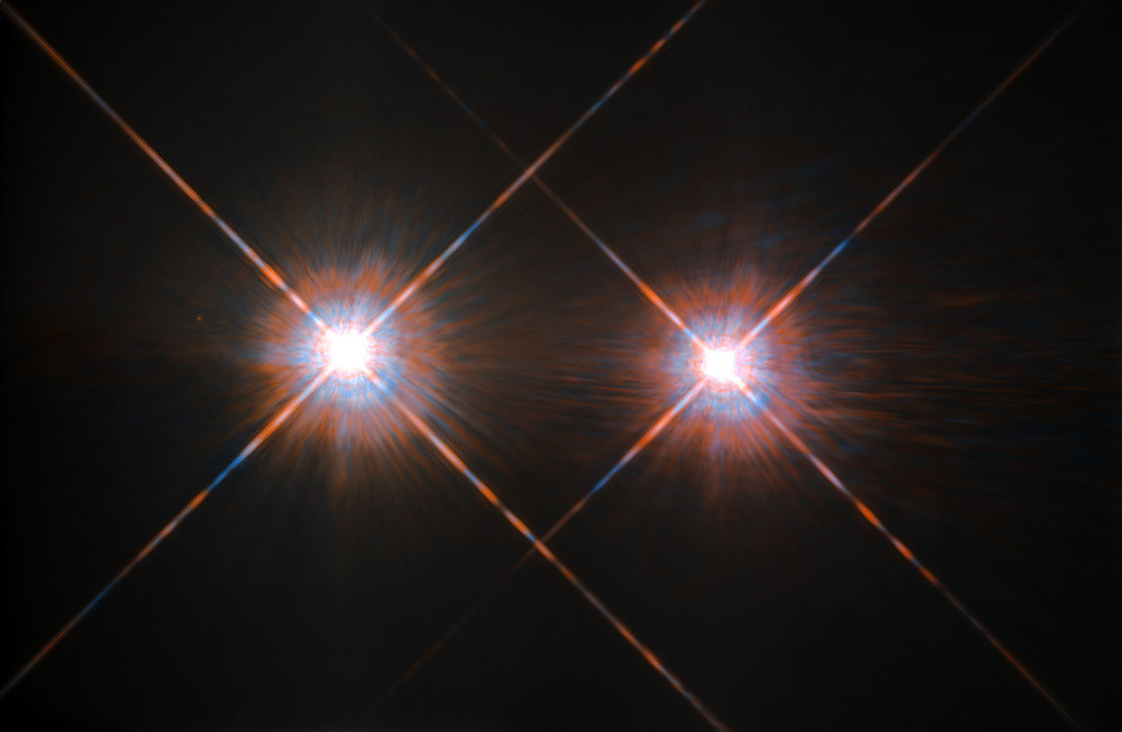 The closest star system to the Earth is the famous Alpha Centauri group. Located in the constellation of Centaurus (The Centaur), at a distance of 4.3 light-years, this system is made up of the binary formed by the stars Alpha Centauri A and Alpha Centauri B, plus the faint red dwarf Alpha Centauri C, also known as Proxima Centauri.  The NASA/ESA Hubble Space Telescope has given us this stunning view of the bright Alpha Centauri A (on the left) and Alpha Centauri B (on the right), flashing like huge cosmic headlamps in the dark. The image was captured by the Wide Field and Planetary Camera 2 (WFPC2). WFPC2 was Hubble’s most used instrument for the first 13 years of the space telescope’s life, being replaced in 2009 by WFC3 during Servicing Mission 4. This portrait of Alpha Centauri was produced by observations carried out at optical and near-infrared wavelengths.  Compared to the Sun, Alpha Centauri A is of the same stellar type G2, and slightly bigger, while Alpha Centauri B, a K1-type star, is slightly smaller. They orbit a common centre of gravity once every 80 years, with a minimum distance of about 11 times the distance between the Earth and the Sun. Because these two stars are, together with their sibling Proxima Centauri, the closest to Earth, they are among the best studied by astronomers. And they are also among the prime targets in the hunt for habitable exoplanets. Using the HARPS instrument astronomers already discovered a planet orbiting Alpha Centauri B. 24 August 2016 astronomers announced the discovery of an Earth-like planet in the habitable zone orbiting the star Proxima Centauri.  Credit: ESA/Hubble & NASA