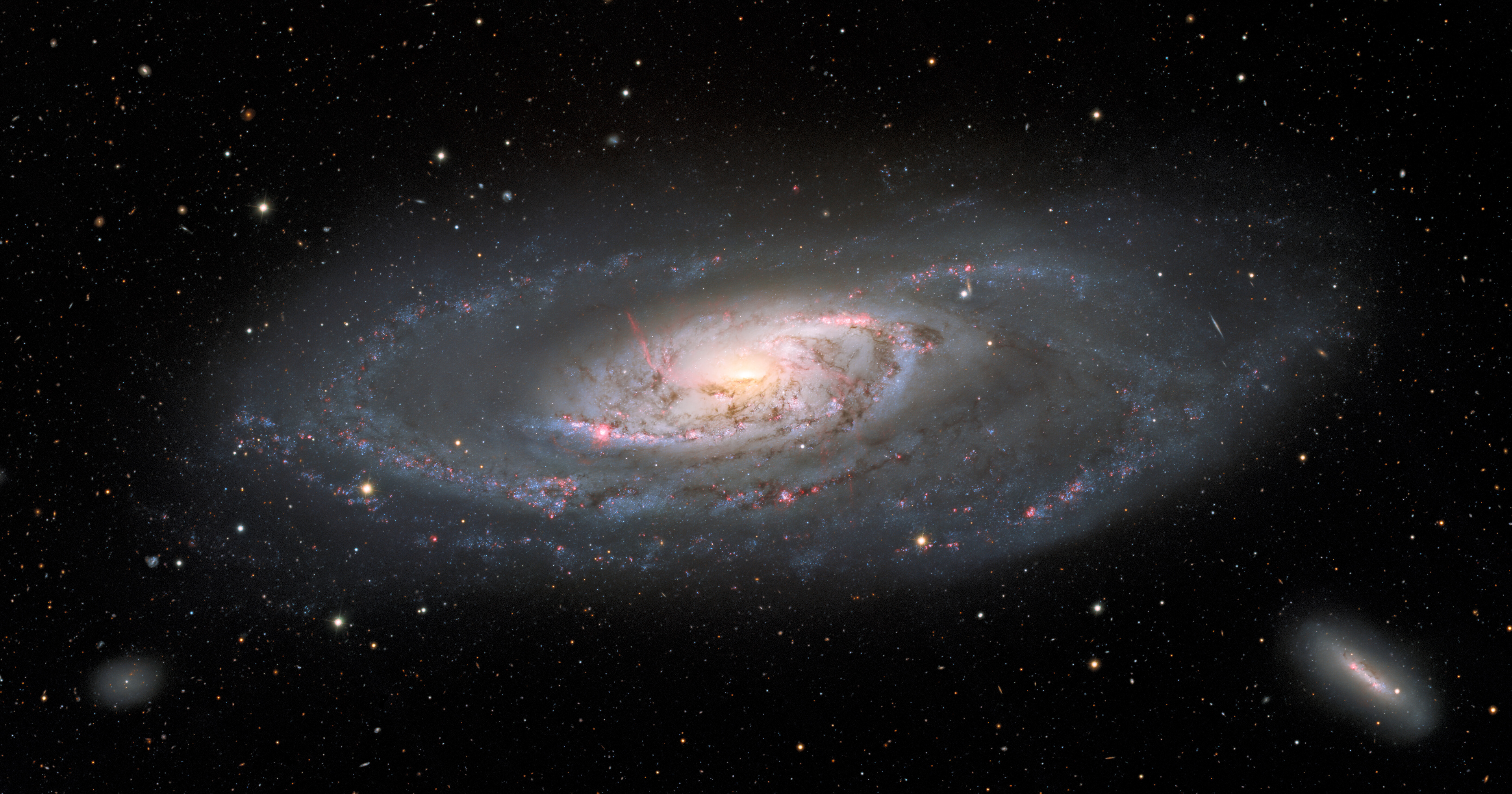This image of the spiral galaxy Messier 106, or NGC 4258, was taken with the Nicholas U. Mayall 4-meter Telescope at Kitt Peak National Observatory, a Program of NSF’s NOIRLab. A popular target for amateur astronomers, Messier 106 can also be spotted with a small telescope in the constellation Canes Venatici. This view captures the entire galaxy, detailing the glowing spiral arms, wisps of gas, and dust lanes at the center of Messier 106 as well as the leisurely twisting bands of stars at the galaxy’s outer edges. Two dwarf galaxies also appear in the image: NGC 4248 in the lower right and UGC 7358 in the lower left.  Credit: KPNO/NOIRLab/NSF/AURA Acknowledgment: PI: M.T. Patterson (New Mexico State University) Image processing: T.A. Rector (University of Alaska Anchorage), M. Zamani & D. de Martin