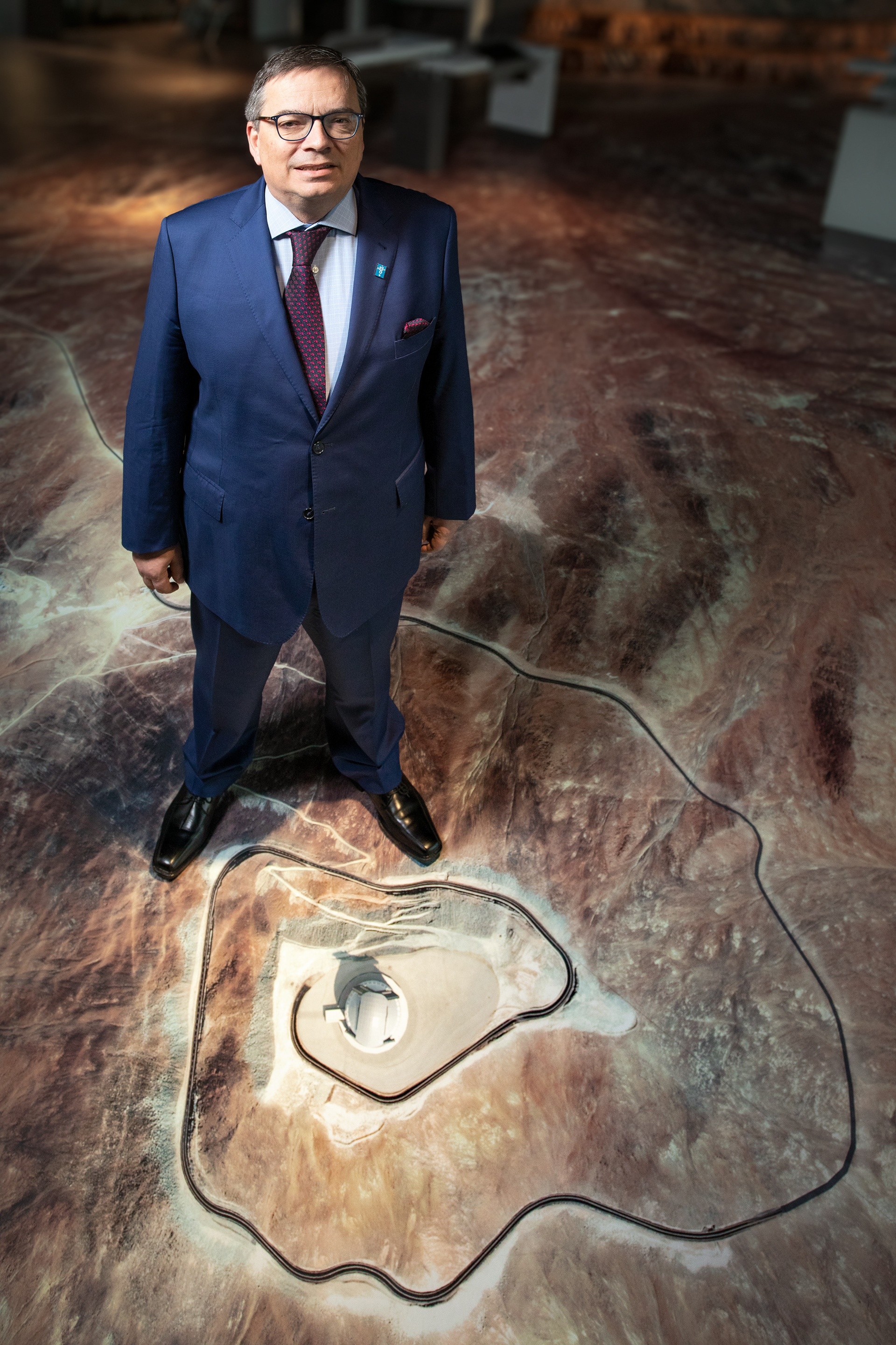 Xavier Barcons, Director General of ESO, standing on a map of ESO's Chilean Sites in the ESO Supernova Planetarium & Visitor Centre in Garching, Germany. At his feet is a Cerro Armazones, site of the future Extremely Large Telescope (ELT), topped with a computer rendering of the ELT dome as it will look once completed.