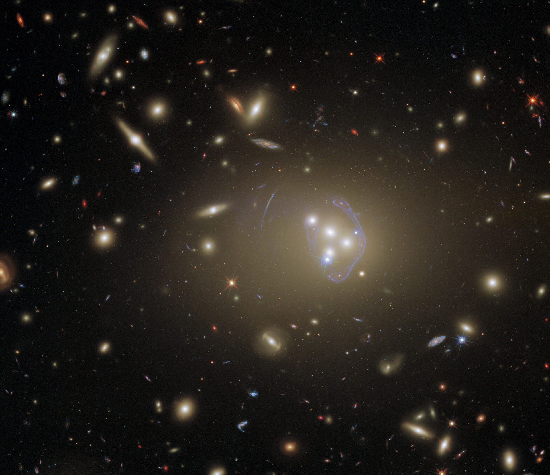 This detailed image features Abell 3827, a galaxy cluster that offers a wealth of exciting possibilities for study. It was observed by Hubble in order to study dark matter, which is one of the greatest puzzles cosmologists face today. The science team used Hubble’s Advanced Camera for Surveys (ACS) and Wide Field Camera 3 (WFC3) to complete their observations. The two cameras have different specifications and can observe different parts of the electromagnetic spectrum, so using them both allowed the astronomers to collect more complete information. Abell 3827 has also been observed previously by Hubble, because of the interesting gravitational lens at its core.   Looking at this cluster of hundreds of galaxies, it is amazing to recall that until less than 100 years ago, many astronomers believed that the Milky Way was the only galaxy in the Universe. The possibility of other galaxies had been debated previously, but the matter was not truly settled until Edwin Hubble confirmed that the Great Andromeda Nebula was in fact far too distant to be part of the Milky Way. The Great Andromeda Nebula became the Andromeda Galaxy, and astronomers recognised that our Universe was much, much bigger than humanity had imagined. We can only imagine how Edwin Hubble — after whom the Hubble Space Telescope was named — would have felt if he’d seen this spectacular image of Abell 3827.  Credit: ESA/Hubble & NASA, R. Massey