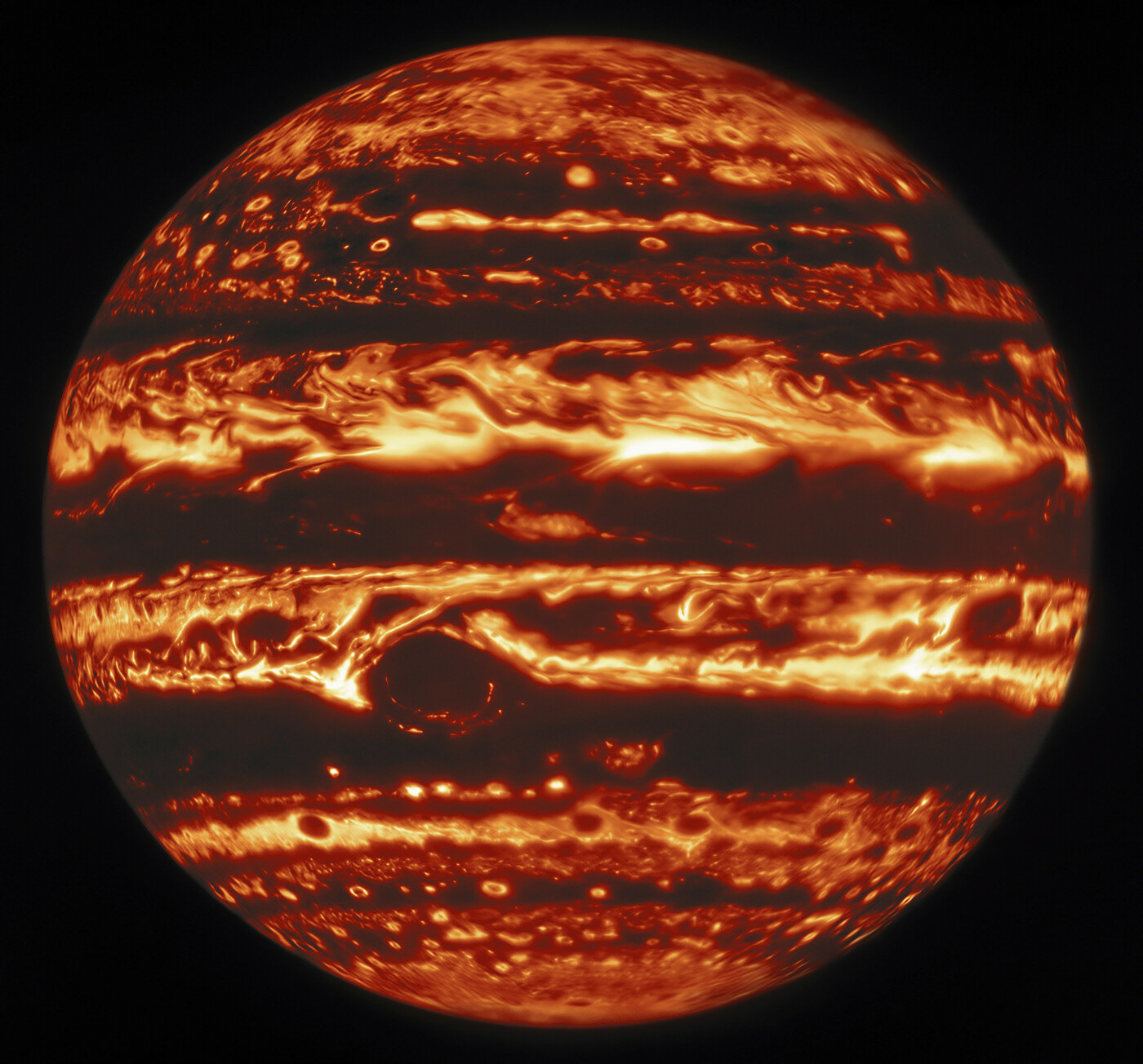 This infrared view of Jupiter was created from data captured on 11 January 2017 with the Near-InfraRed Imager (NIRI) instrument at Gemini North in Hawaiʻi, the northern member of the international Gemini Observatory, a Program of NSF’s NOIRLab. It is actually a mosaic of individual frames that were combined to produce a global portrait of the planet.  In the image warmer areas appear bright, including four large hot spots that appear in a row just north of the equator. South of the equator, the oval-shaped and cloud-covered Great Red Spot appears dark.  Credit: International Gemini Observatory/NOIRLab/NSF/AURA, M.H. Wong (UC Berkeley) et al. Acknowledgments: M. Zamani