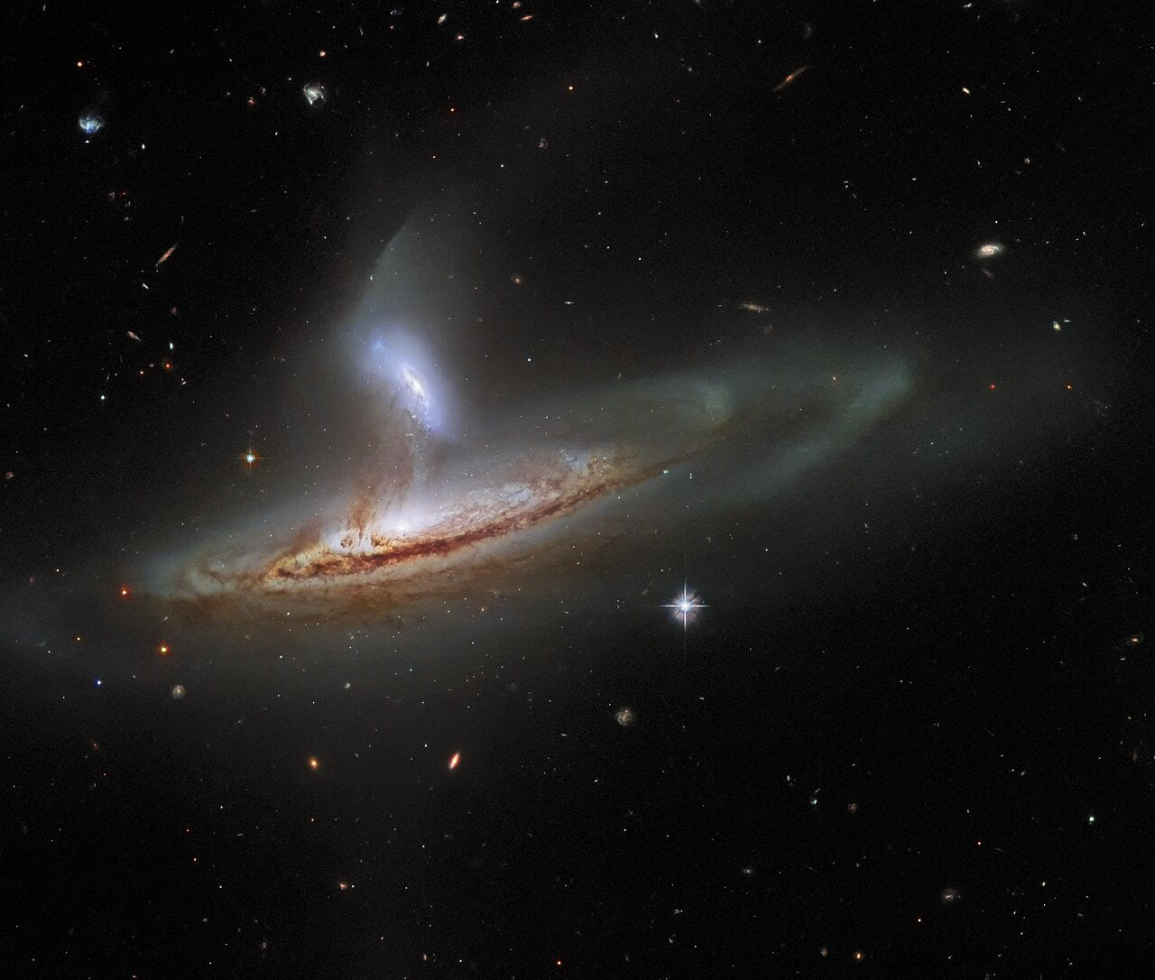 It is now widely accepted amongst astronomers that an important aspect of how galaxies evolve is the way they interact with one another. Galaxies can merge, collide, or brush past one another — each of which has a significant impact on their shapes and structures. As common as these interactions are thought to be in the Universe, it is rare to capture an image of two galaxies interacting in such a visibly dynamic way. This image, from the NASA/ESA Hubble Space Telescope, feels incredibly three-dimensional for a piece of deep-space imagery.   The subject of this image is named Arp 282, an interacting galaxy pair that is composed of the Seyfert galaxy NGC 169 (bottom) and the galaxy IC 1559 (top). If you’re interested in learning more about Seyfert galaxies, you can read about the Seyfert galaxy NGC 5728 here. Interestingly, both of the galaxies comprising Arp 282 have monumentally energetic cores, known as active galactic nuclei (AGN), although it is difficult to tell that from this image. This is actually rather fortunate, because if the full emission of two AGNs was visible in this image, then it would probably obscure the beautifully detailed tidal interactions occurring between NGC 169 and IC 1559. Tidal forces occur when an object’s gravity causes another object to distort or stretch. The direction of the tidal forces will be away from the lower-mass object and towards the higher mass object. When two galaxies interact, gas, dust and even entire solar systems will be drawn away from one galaxy towards the other by these tidal forces. This process can actually be seen in action in this image — delicate streams of matter have formed, visibly linking the two galaxies.  Credit: ESA/Hubble & NASA, J. Dalcanton, Dark Energy Survey, DOE, FNAL/DECam, CTIO/NOIRLab/NSF/AURA, SDSS Acknowledgement: J. Schmidt