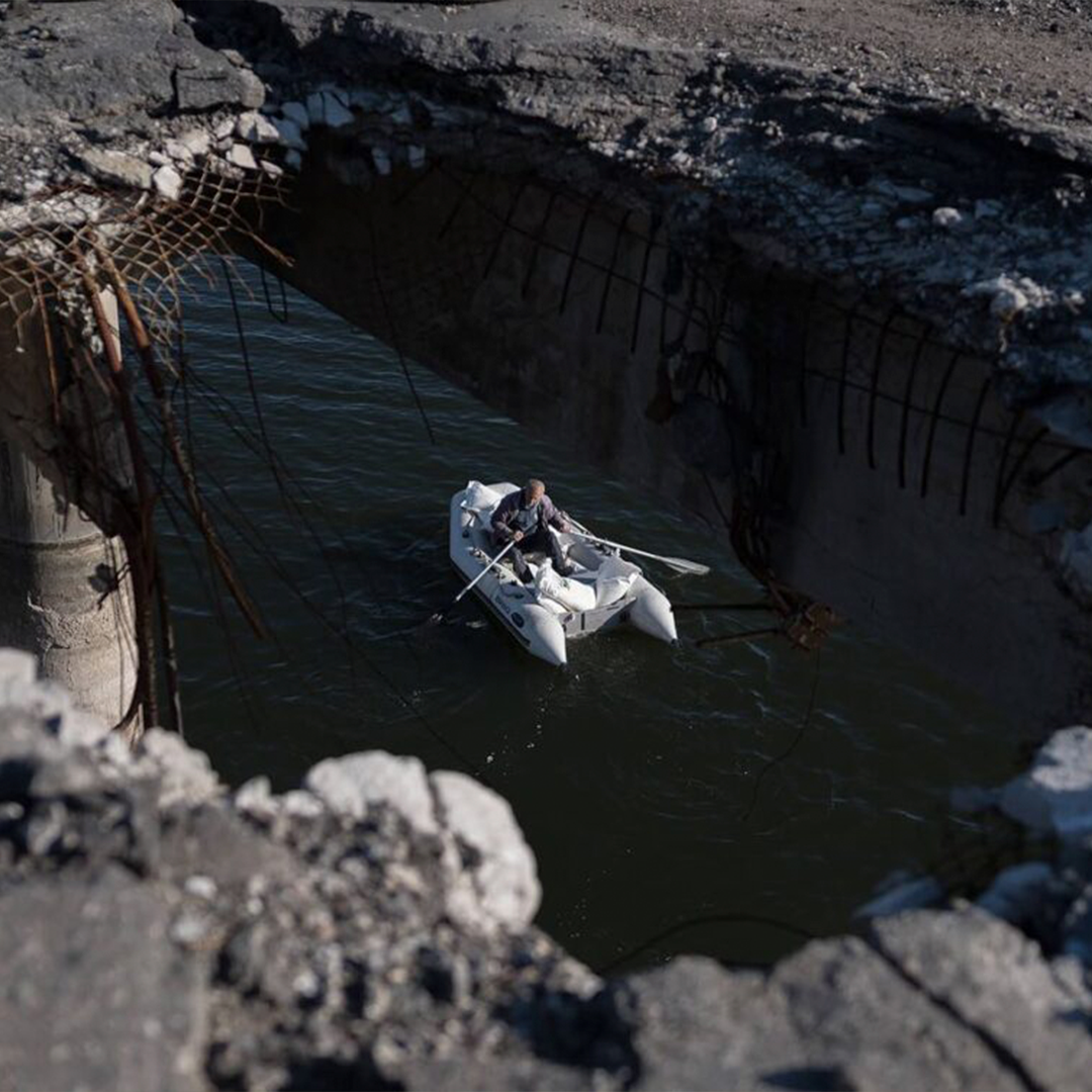 Ukrainian man on a boat under a destroyed bridge