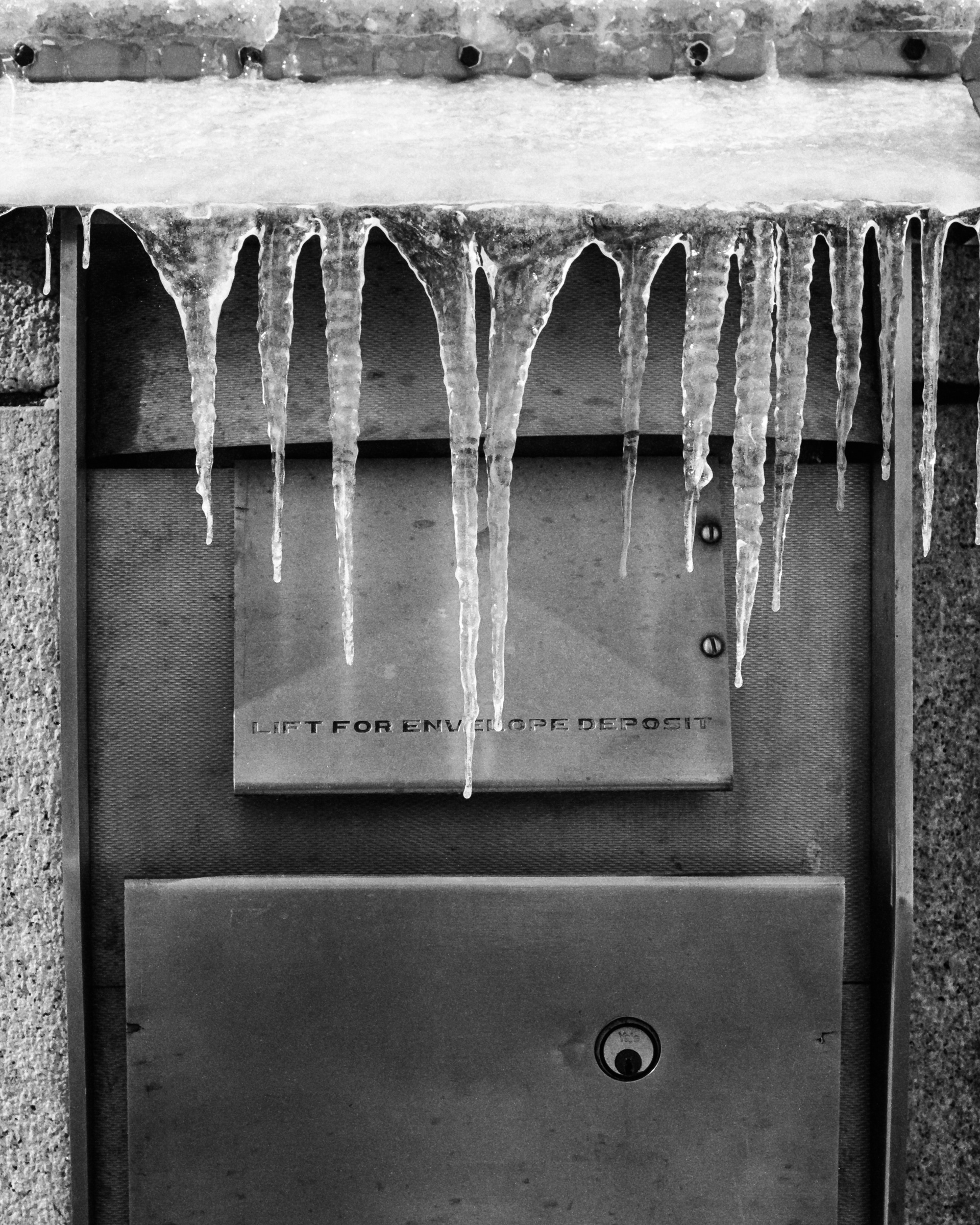 A bank drop box covered in snow and ice.