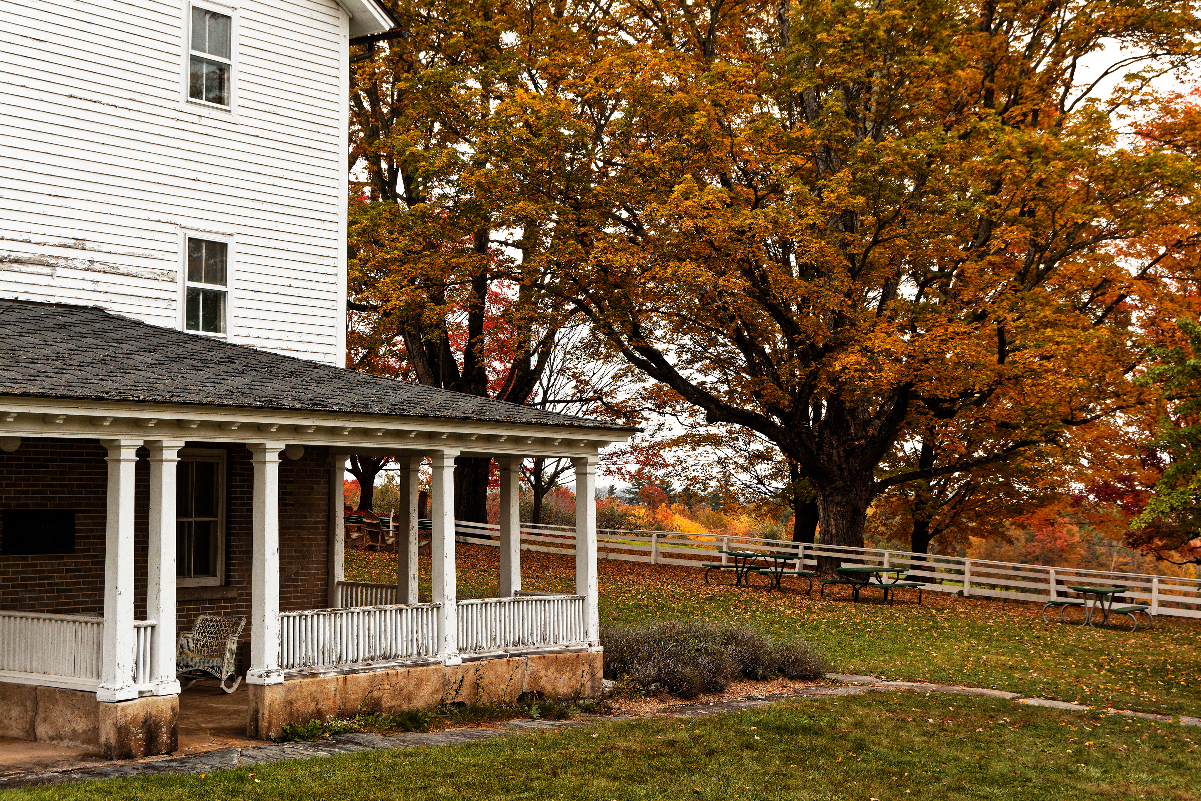 The backside of the Enfield house with a single white chair on the porch