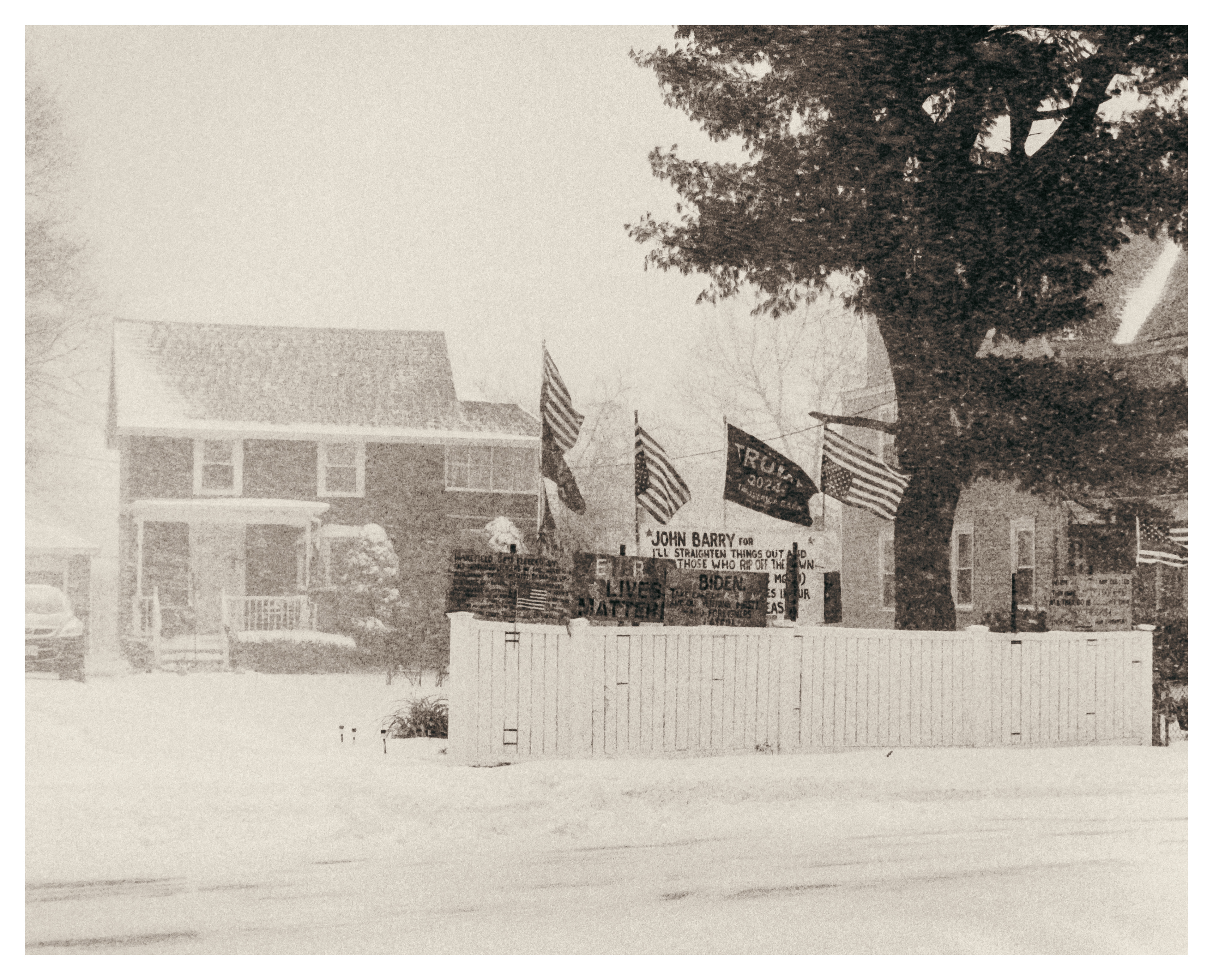 A home with several signs and banners during a blizzard