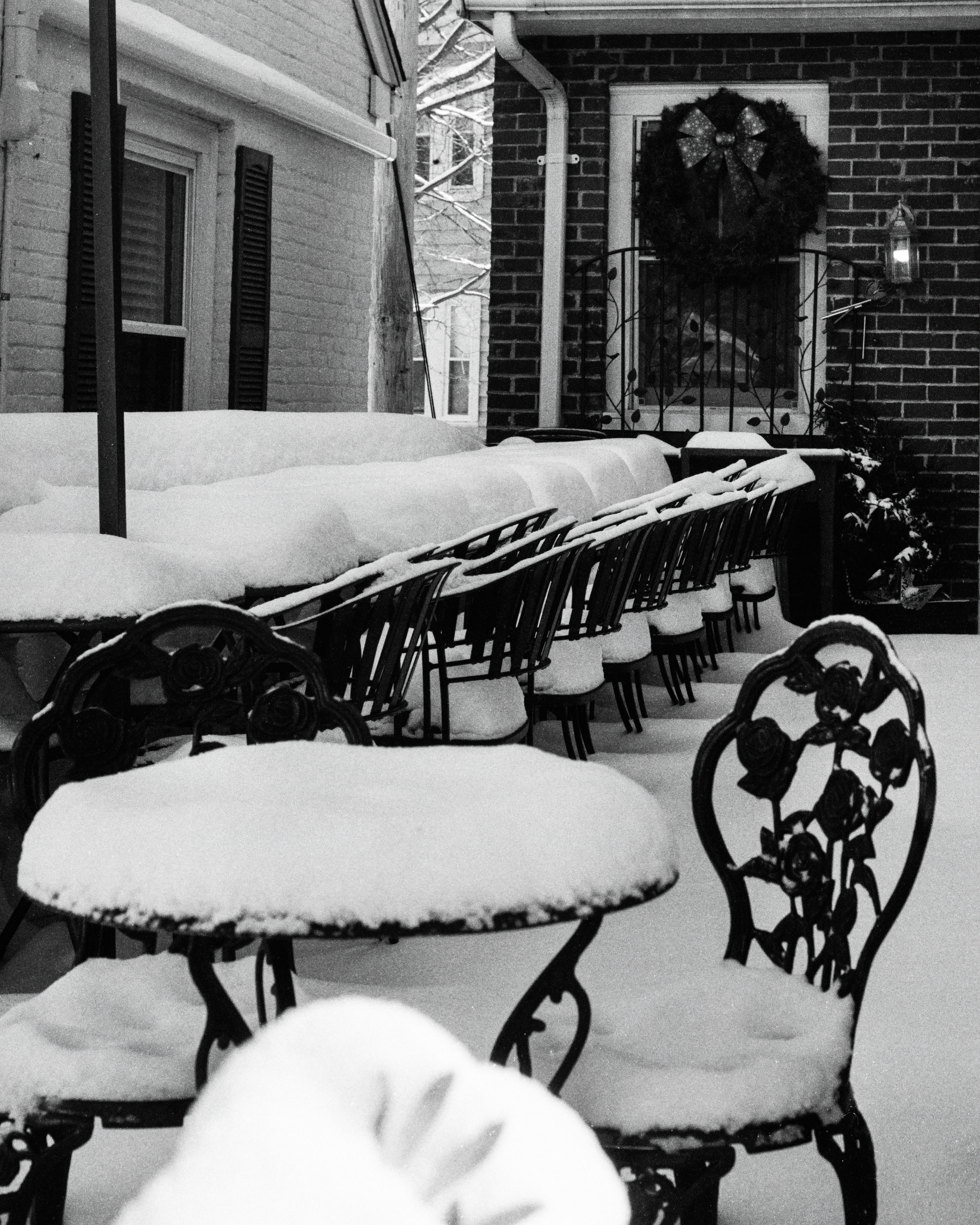 Outdoor restaurant seating area covered in snow after a storm.
