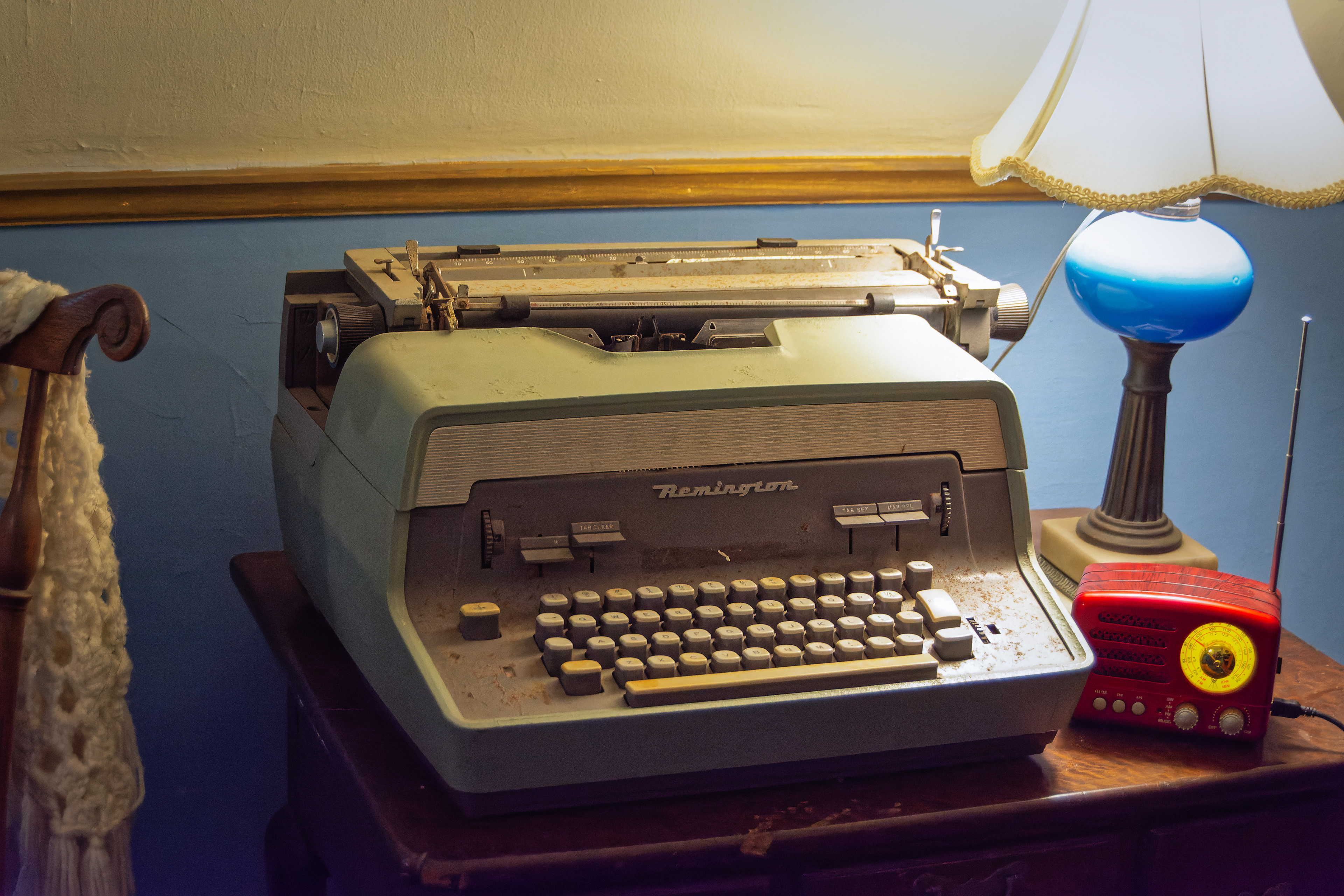Remington typewriter on desk next to vintage radio