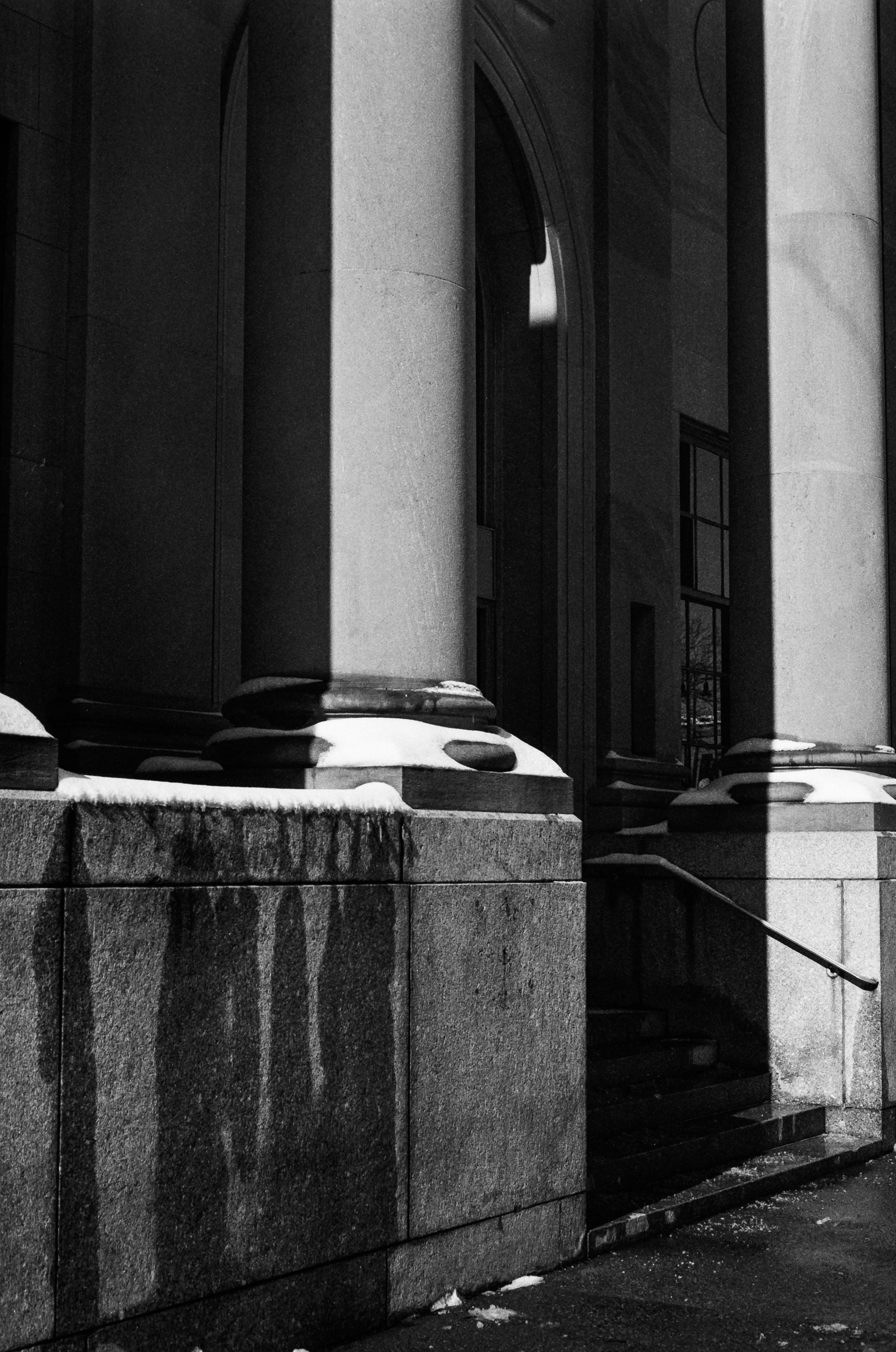 Stone columns in front of official building after snow storm.