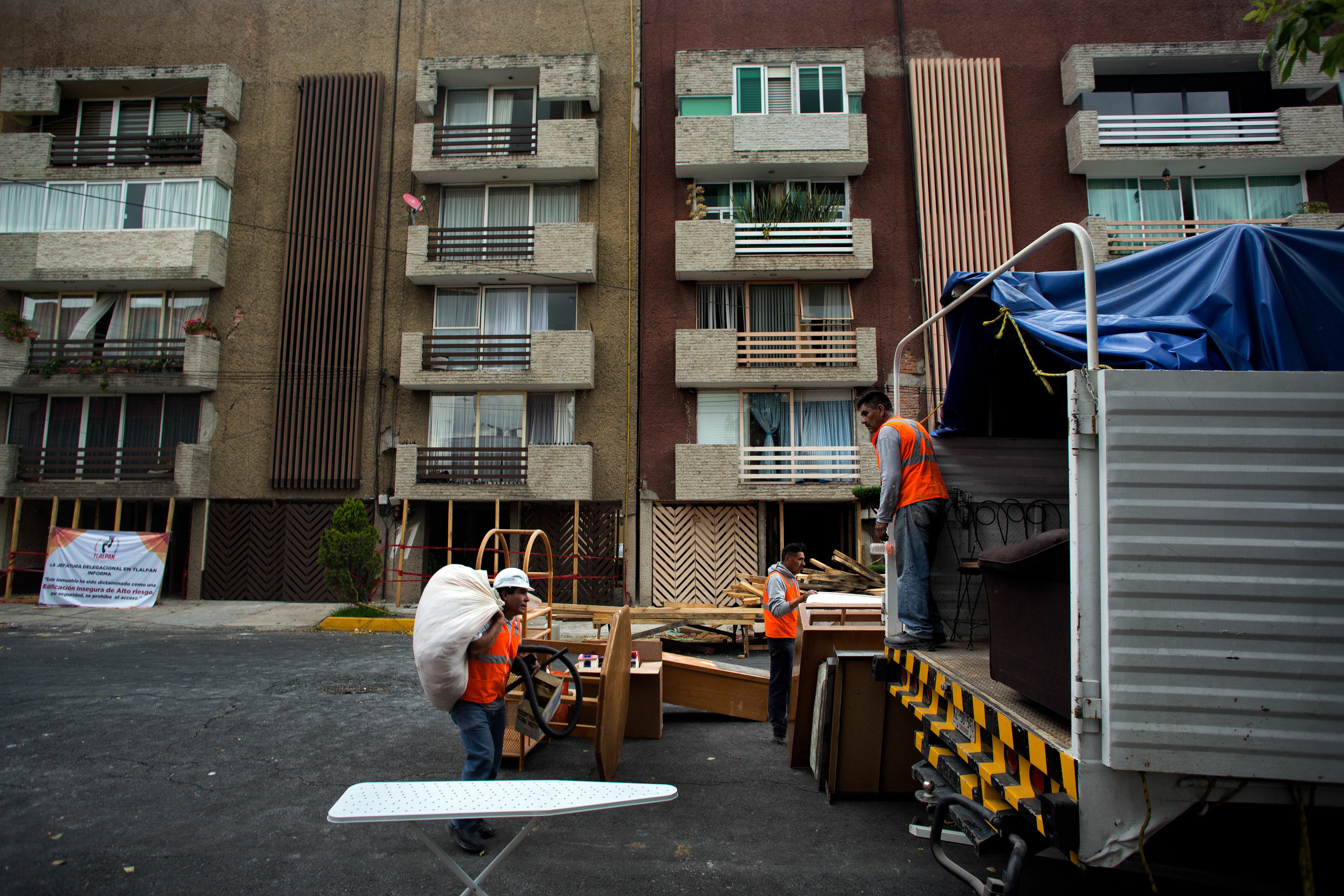 Habitantes de un edificio en Prados Coapa Segunda Sección recogen sus pertenencias a un camión de mudanza después de evacuar el edificio dañado en el que vivían, el 12 de octubre de 2017. (foto: Prometeo Lucero)