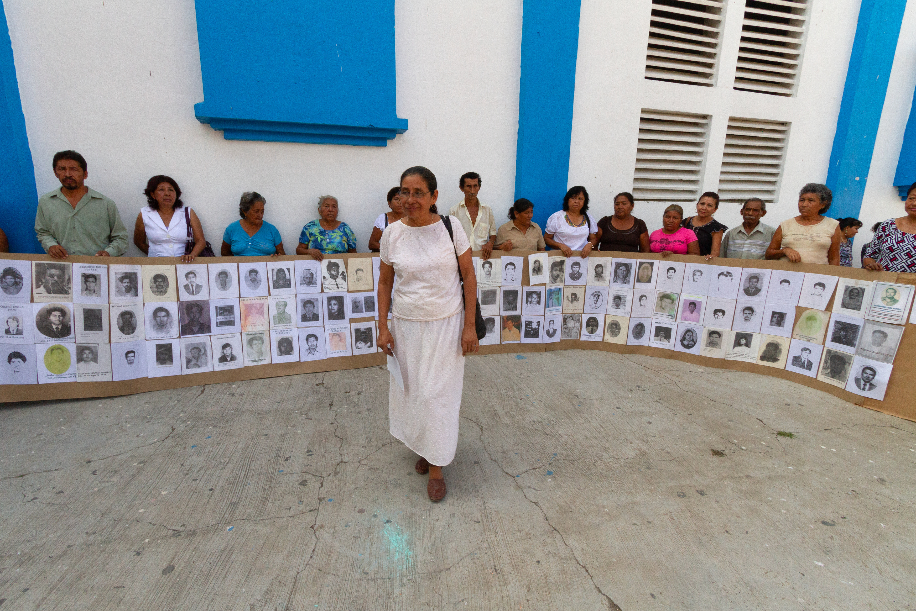 Tita Radilla, hija de Rosendo Radilla y familiares de víctimas de desaparición forzada muestran fotografías de sus familiares a las afueras de la iglesia después de una misa en su honor, en Atoyac, Guerrero, el 14 de noviembre de 2011. (Foto: Prometeo Lucero / PBI México)