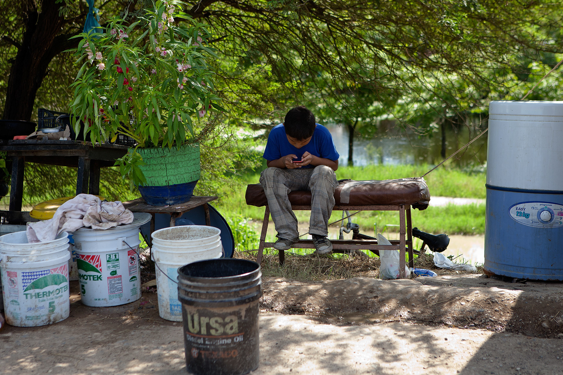 Un niño observa su teléfono móvil en un campamento de personas desplazadas tras la inundación del Río Pánuco en Veracruz. (Foto: Prometeo Lucero)
