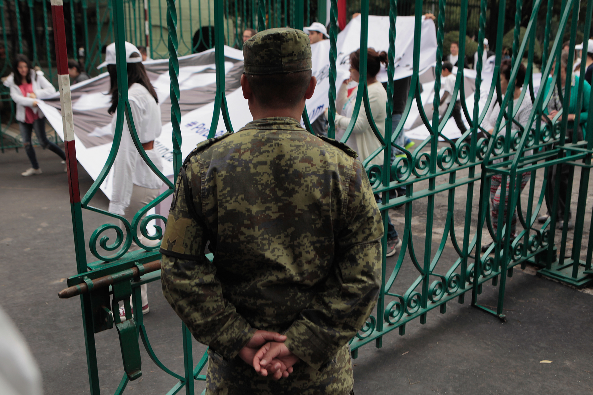 Un elemento de la Policía Militar abre el acceso al Campo Militar Número 1 para permitir el acceso de la “Marcha silenciosa por la paz” en apoyo a las fuerzas armadas, evento convocado por organizaciones empresariales y eclesiásticas. Ciudad de México, 31 de mayo de 2015. (foto: Prometeo Lucero)
