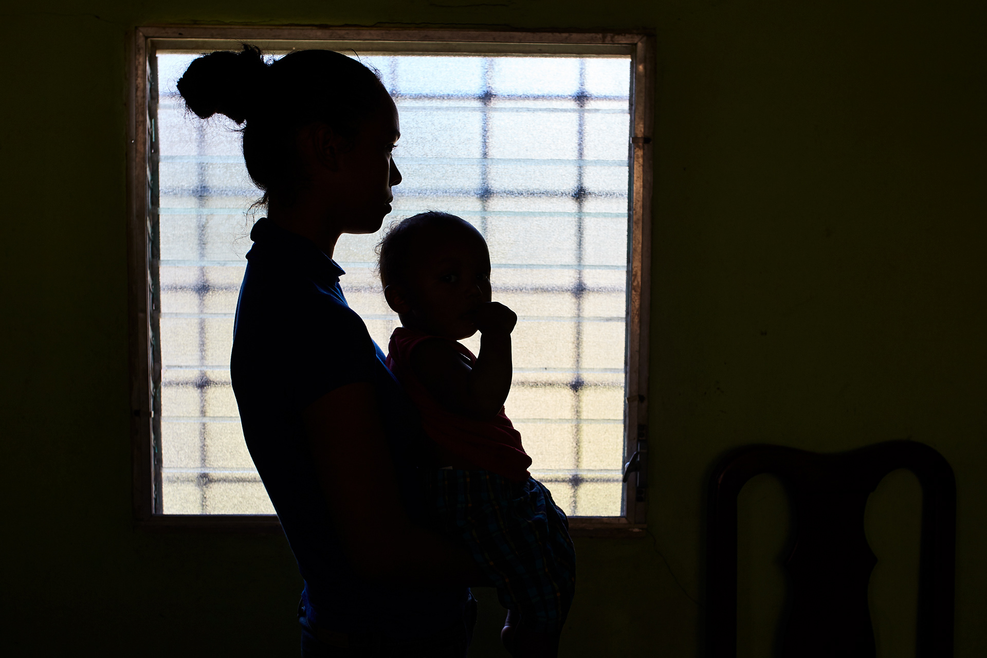 Rosi Aguilar (nombre cambiado) es retratada en el interior de su casa en Choloma, Honduras, antes de que emprenda el viaje hacia los Estados Unidos para alejarse de la violencia de las pandillas. (foto: Prometeo Lucero / Newsweek)