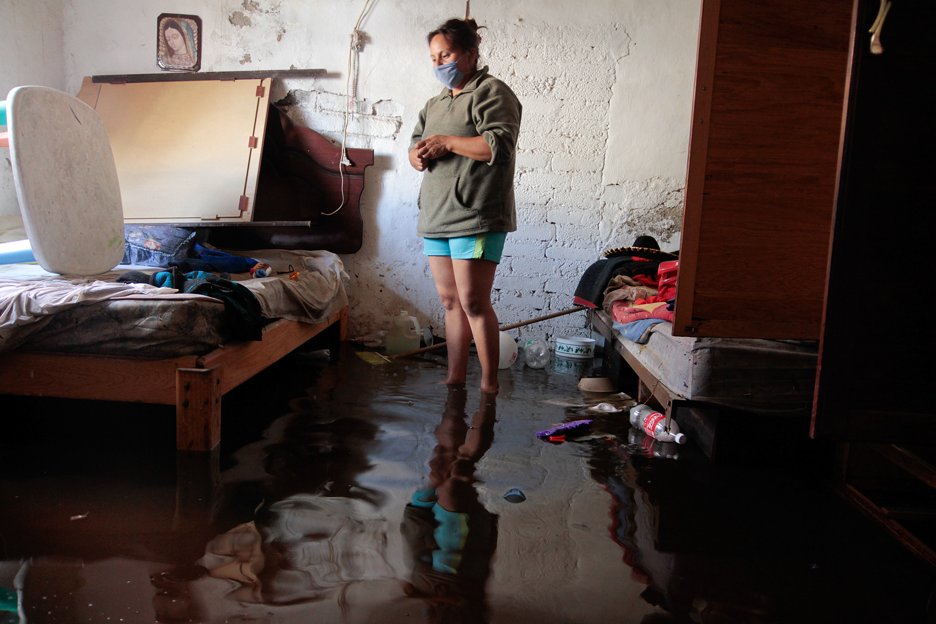 María López Gutierrez observa las pertenencias de su familia en su casa inundada en la Colonia el Sol, Ciudad Nezahualcóyotl, a las afueras de la Ciudad de México, el 28 de junio de 2011.  El día anterior, el Bordo de Xochiaca, un río ubicado en el Estado de México que transporta desperdicios del área metropolitana se desbordó debido a las fuertes lluvias, inundando casas y calles. (foto: Prometeo Lucero / AP)