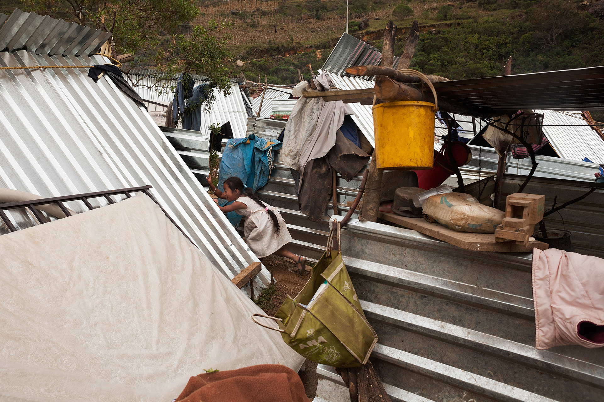 Una niña na'savi juega entre las casas de lámina en el campamento de desplazados de San Miguel Amoltepec Viejo, Cochoapa el Grande, Guerrero. (Foto: Prometeo Lucero)