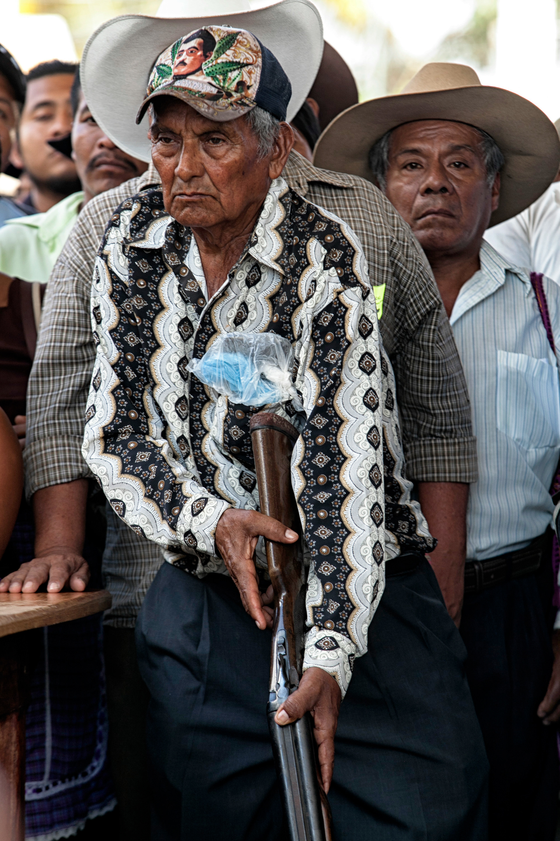 Un hombre armado con una gorra de Jesús Malverde hace presencia en medio de una asamblea comunitaria en San Luis Acatlán, Guerrero, el 23 de febrero de 2013. (FOTO: Prometeo Lucero)
