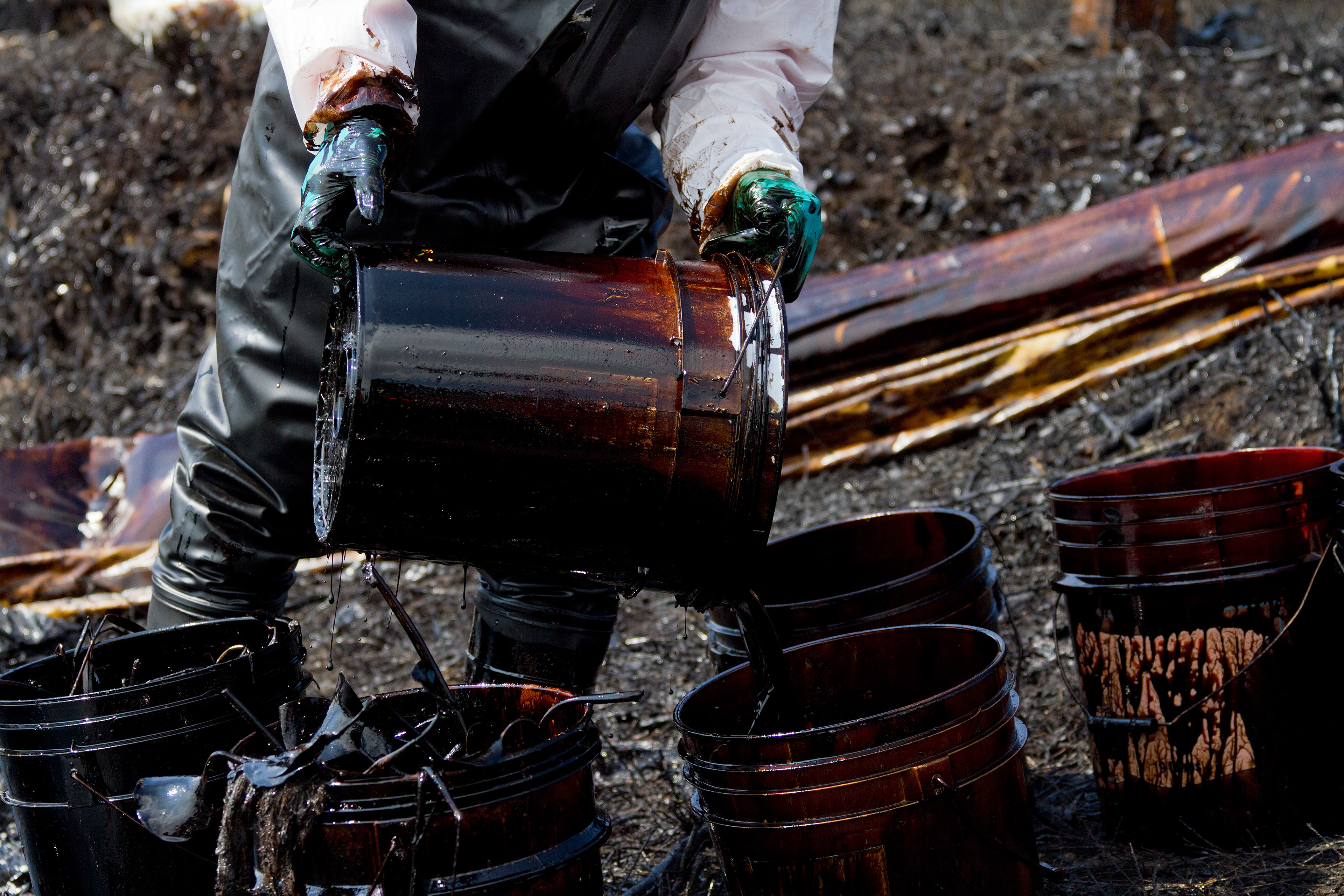 Pescadores locales limpian el petróleo crudo derramado por Pemex en el Río Coatzacoalcos el 31 de diciembre de 2011. El derrame cubrió una mancha de unos 12 kilómetros hasta la desembocadura al mar. Arbustos, peces y lirios quedaron totalmente sumergidos y más de mil pescadores perdieron su medio de subsistencia. 7 de enero de 2012. (Foto: Prometeo Lucero/Greenpeace)