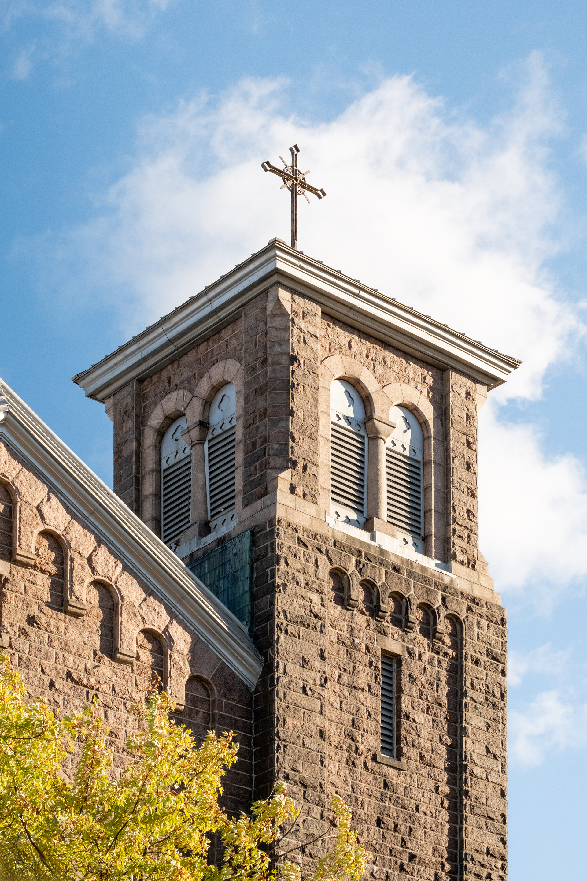 Clocher de l'église Sainte-Famille éclairé par un coucher de coleil, ciel bleu. Situé au Saguenay