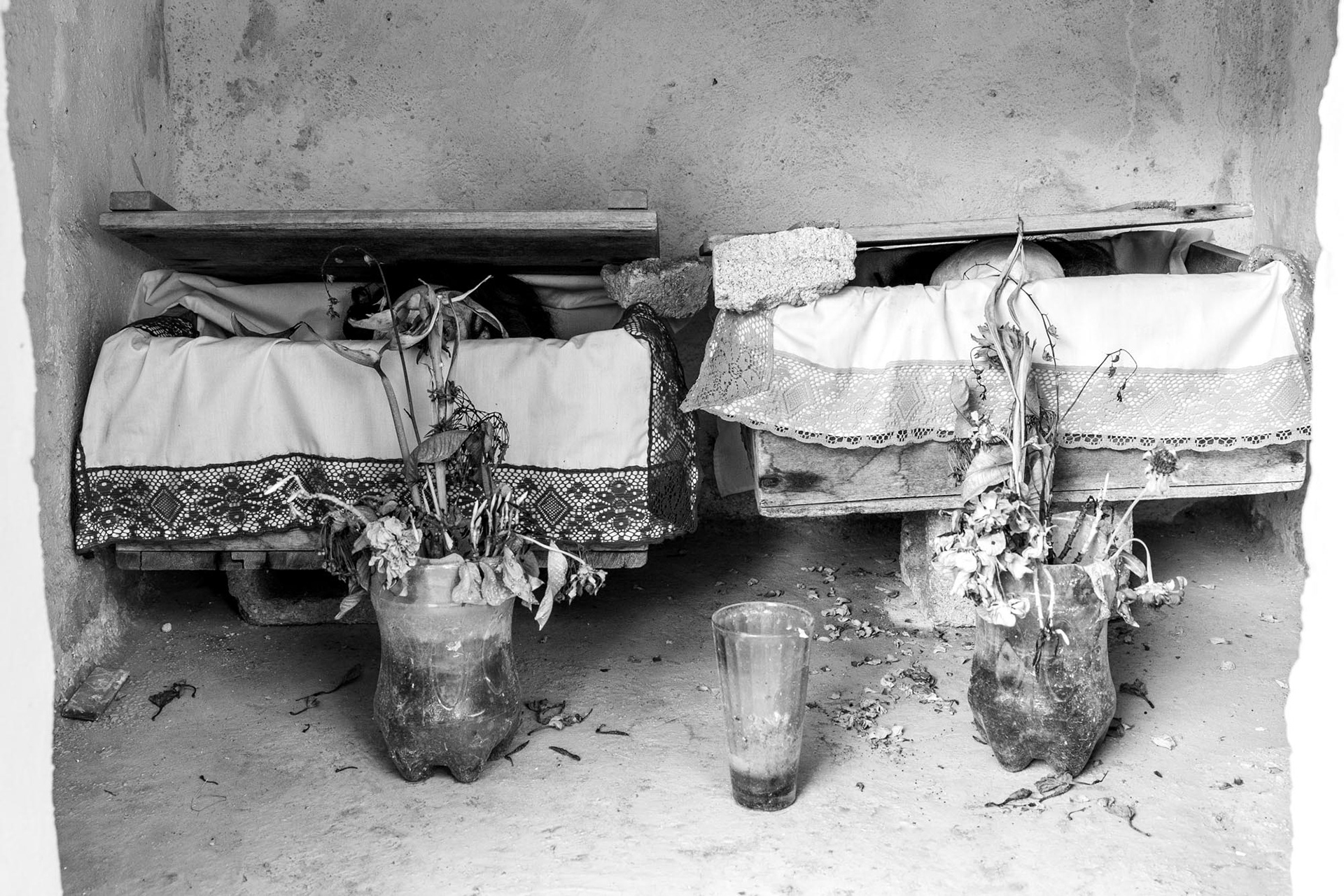 Dried bones wrapped in embroidered cloth are placed in wooden crates inside a niche at the cemetery of Pomuch, Campeche.