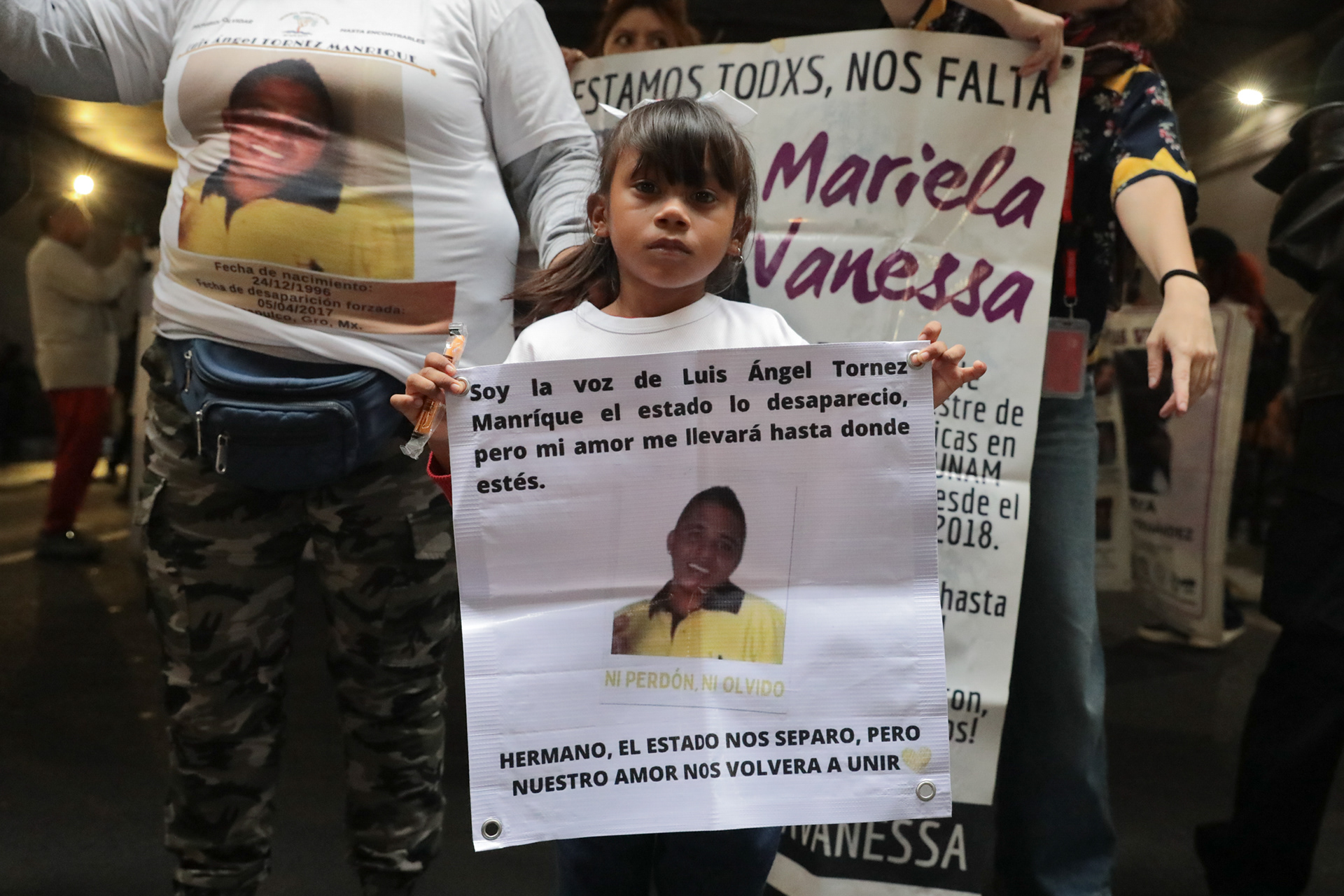 A young girl raises a sign for Luis Ángel Tornez, missing since 2017. Mexico City, Mexico. 2025