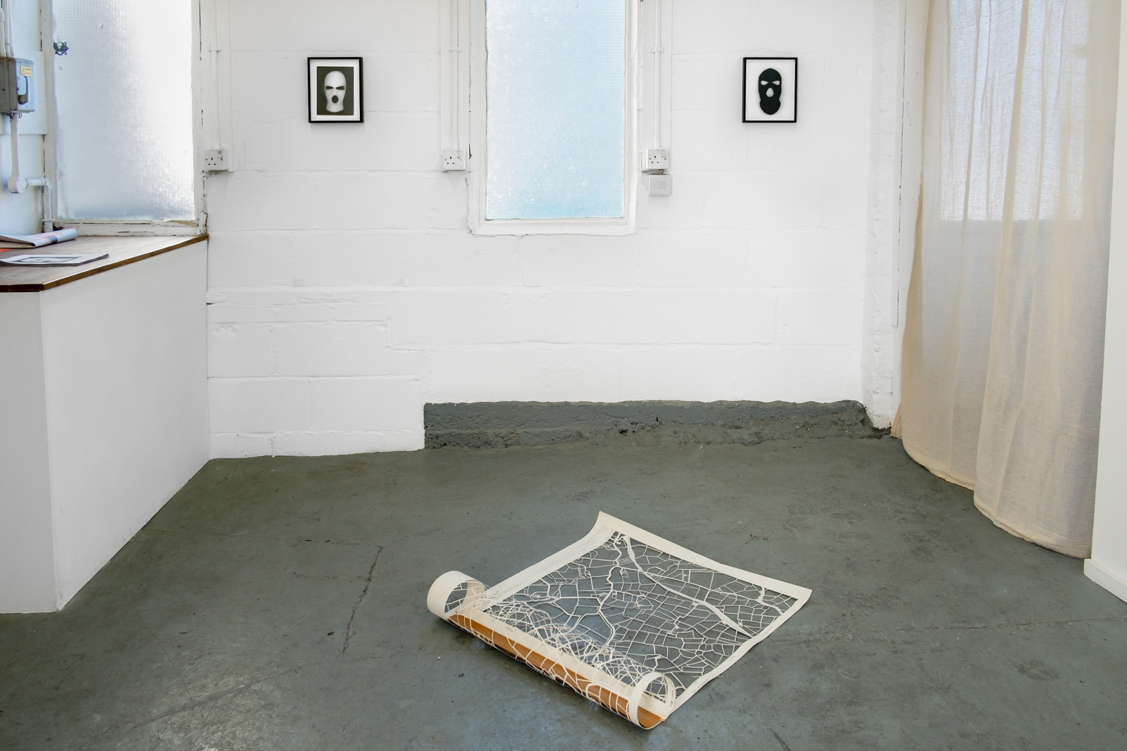 Exhibition installation by martin seeds of northern Ireland maps and terrorist ski mask photographs
