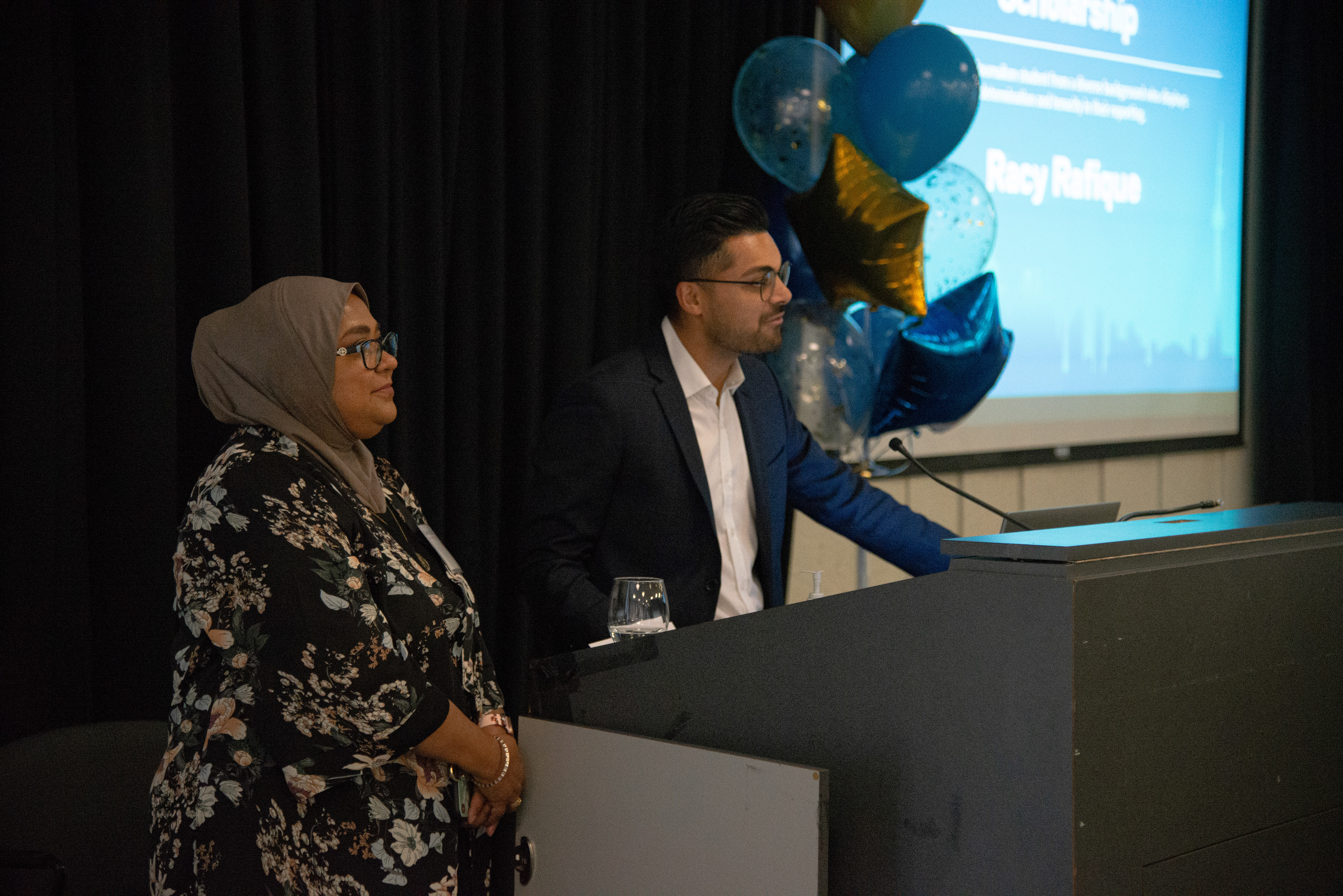 Journalists from CBC Toronto present an award to Toronto Metropolitan University student Racy Rafique at an award ceremony on Nov. 28, 2022. (Aloysius Wong)