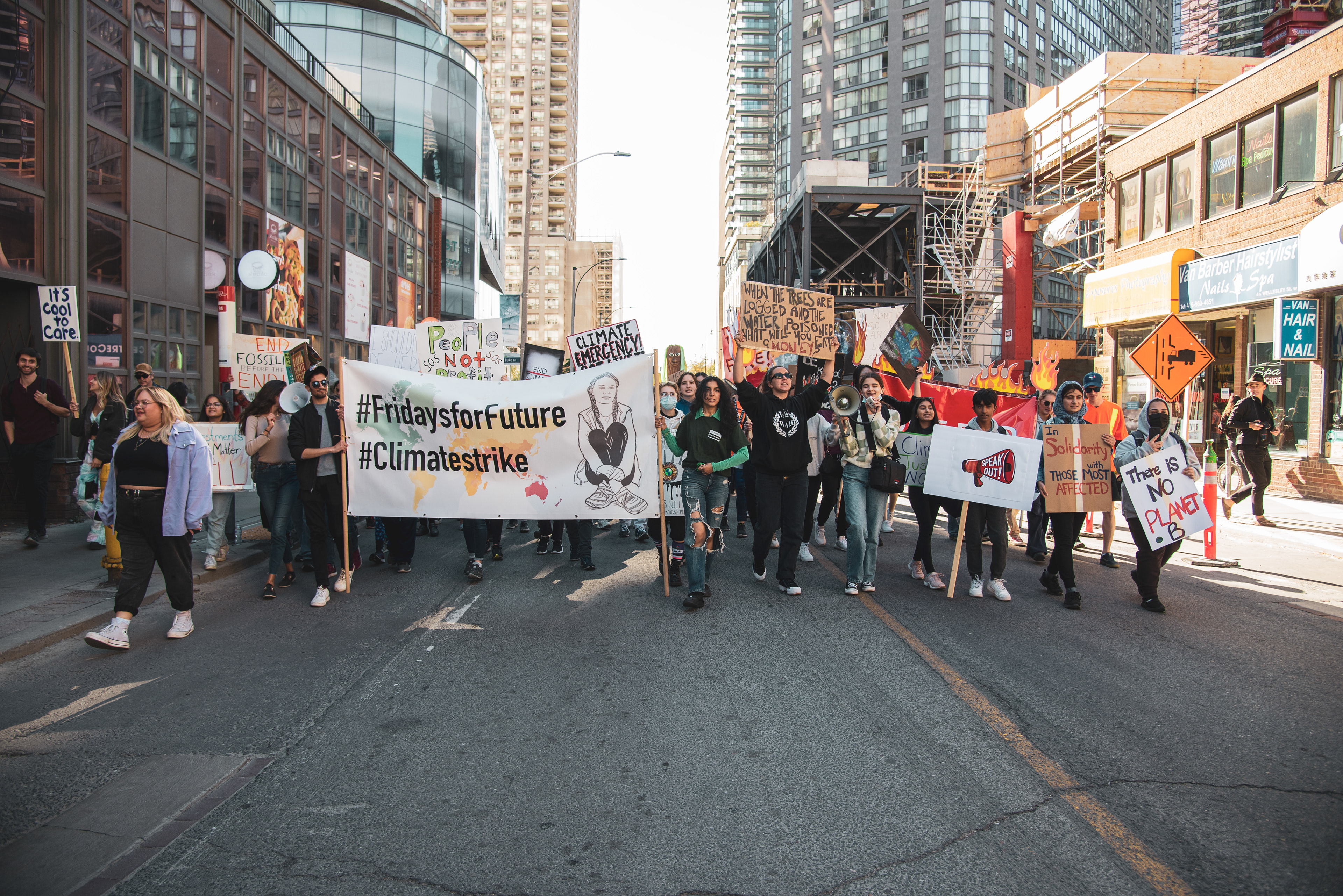 A crowd of protesters demanding climate action march south on Yonge Street.