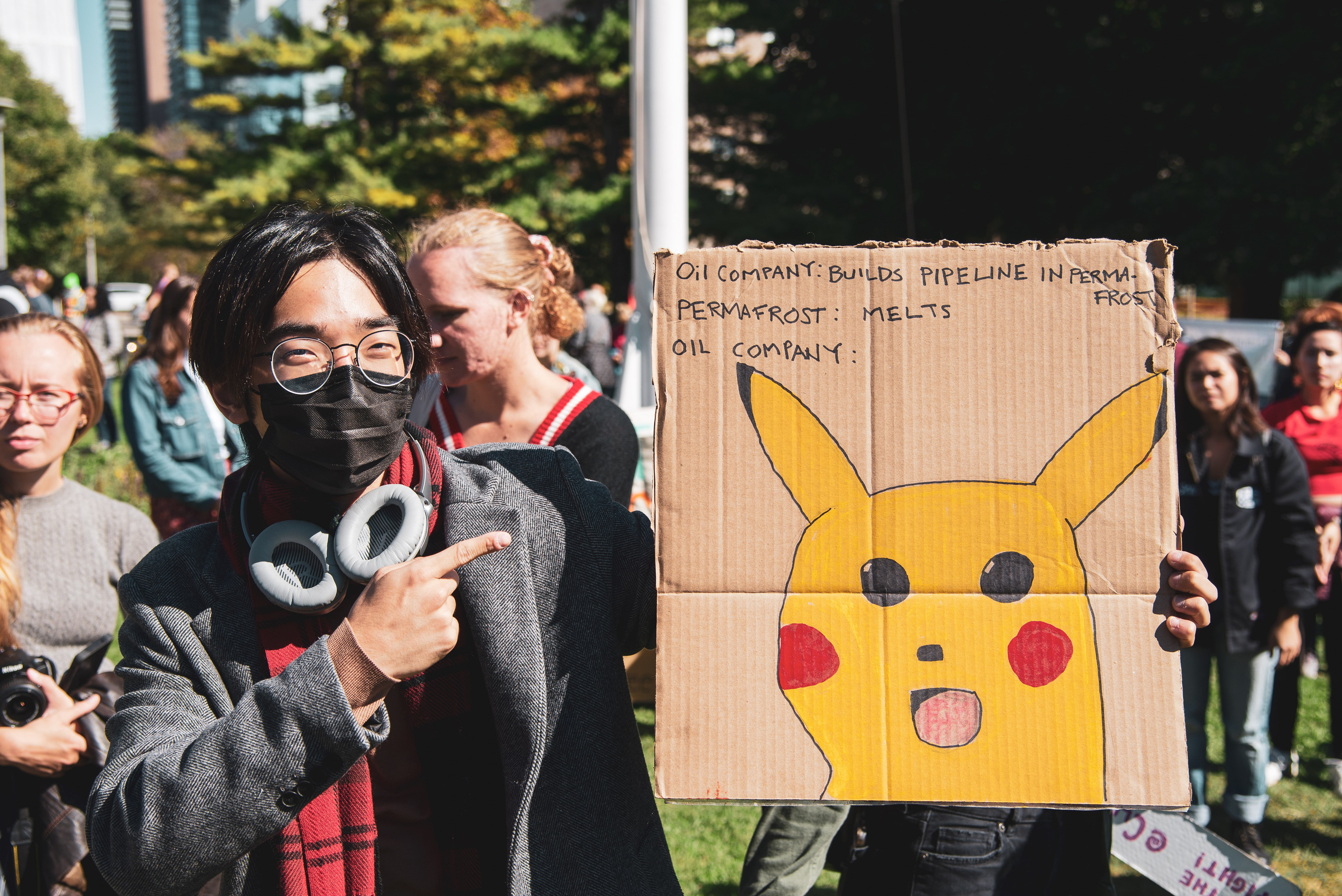 A young man shows a sign mocking oil companies.