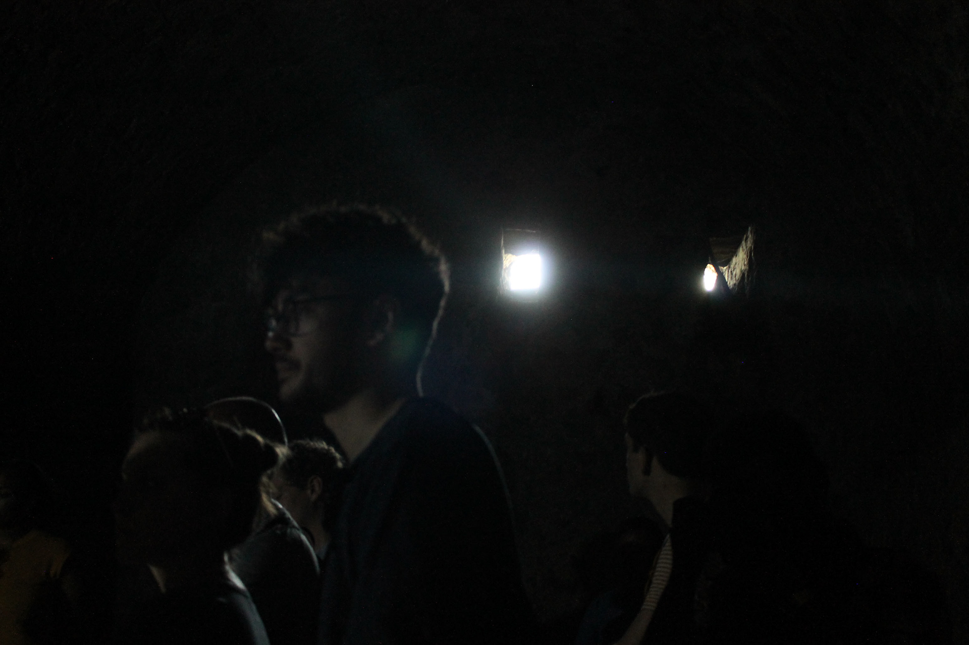 University of Oregon students experiencing the true darkness of the dungeons in Cape Coast Castle.