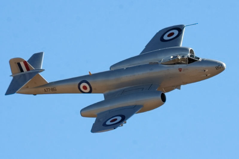 A silver De Havilland Vampire jet aircraft, marked with "A77-851" and "851", displaying roundels on wings and tail.