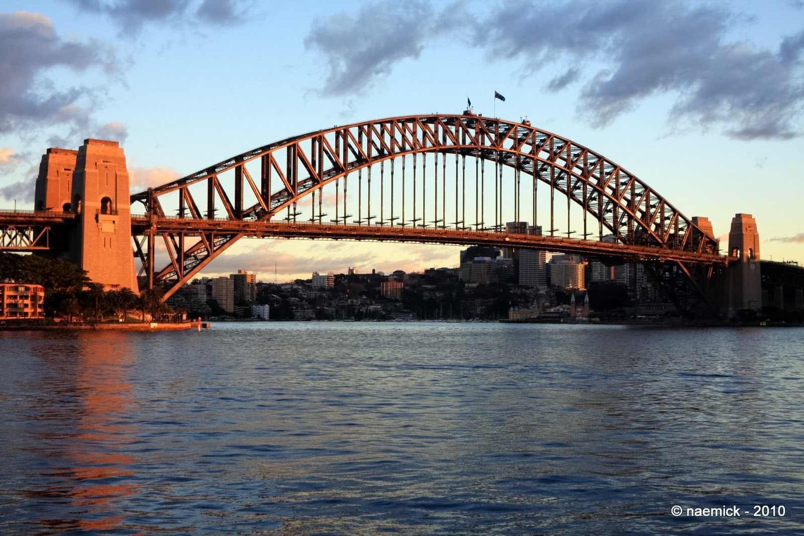 The Sydney Harbour Bridge, an iconic steel arch bridge, spans across Sydney Harbour in Sydney, New South Wales, Australia.