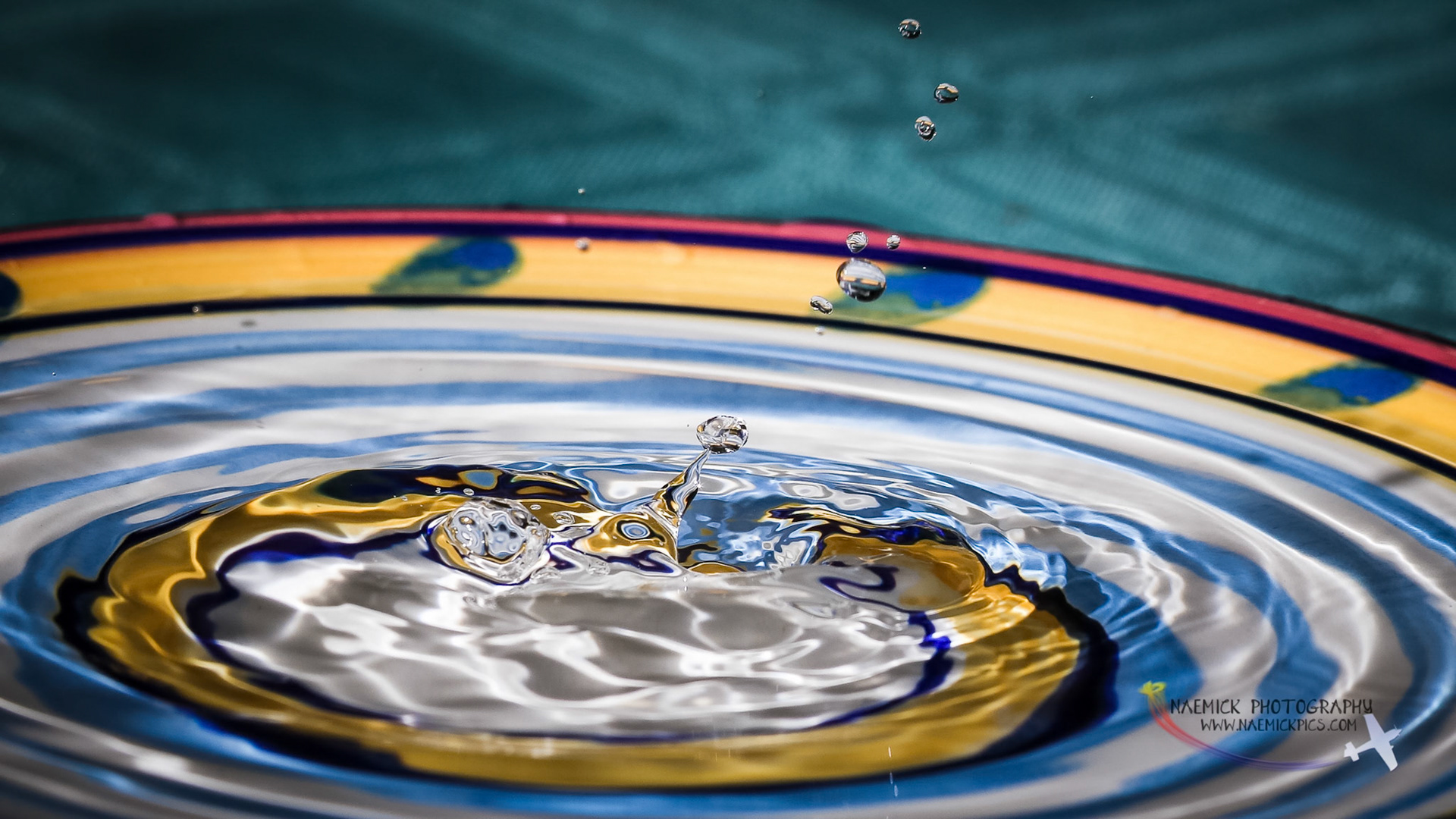 A close-up view captures water droplets creating ripples on the surface of a colorful ceramic bowl in Wagga Wagga.