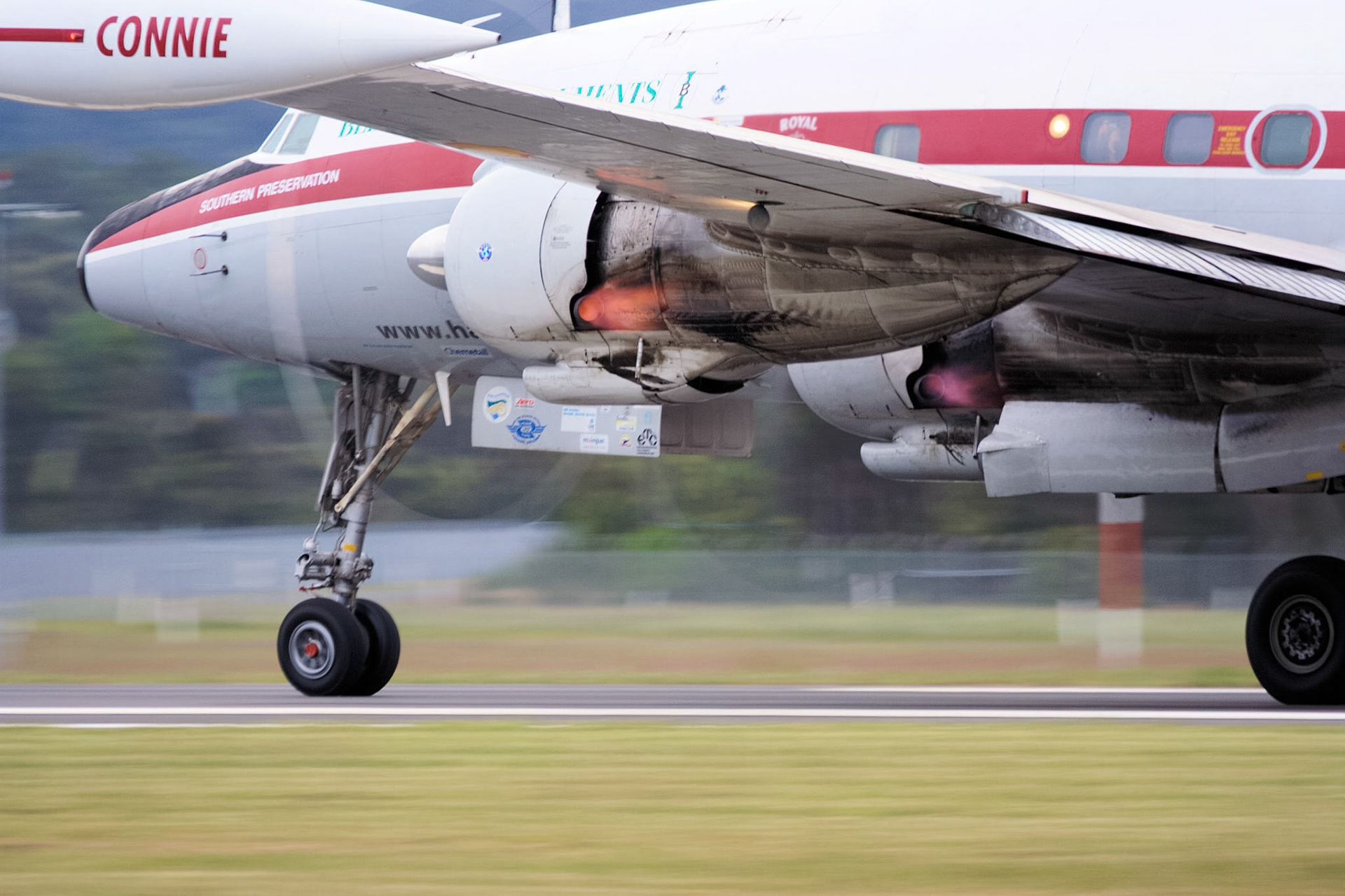 A close-up shot of the "Connie" aircraft, a Lockheed C-121C Constellation, showing its landing gear and engine exhaust.