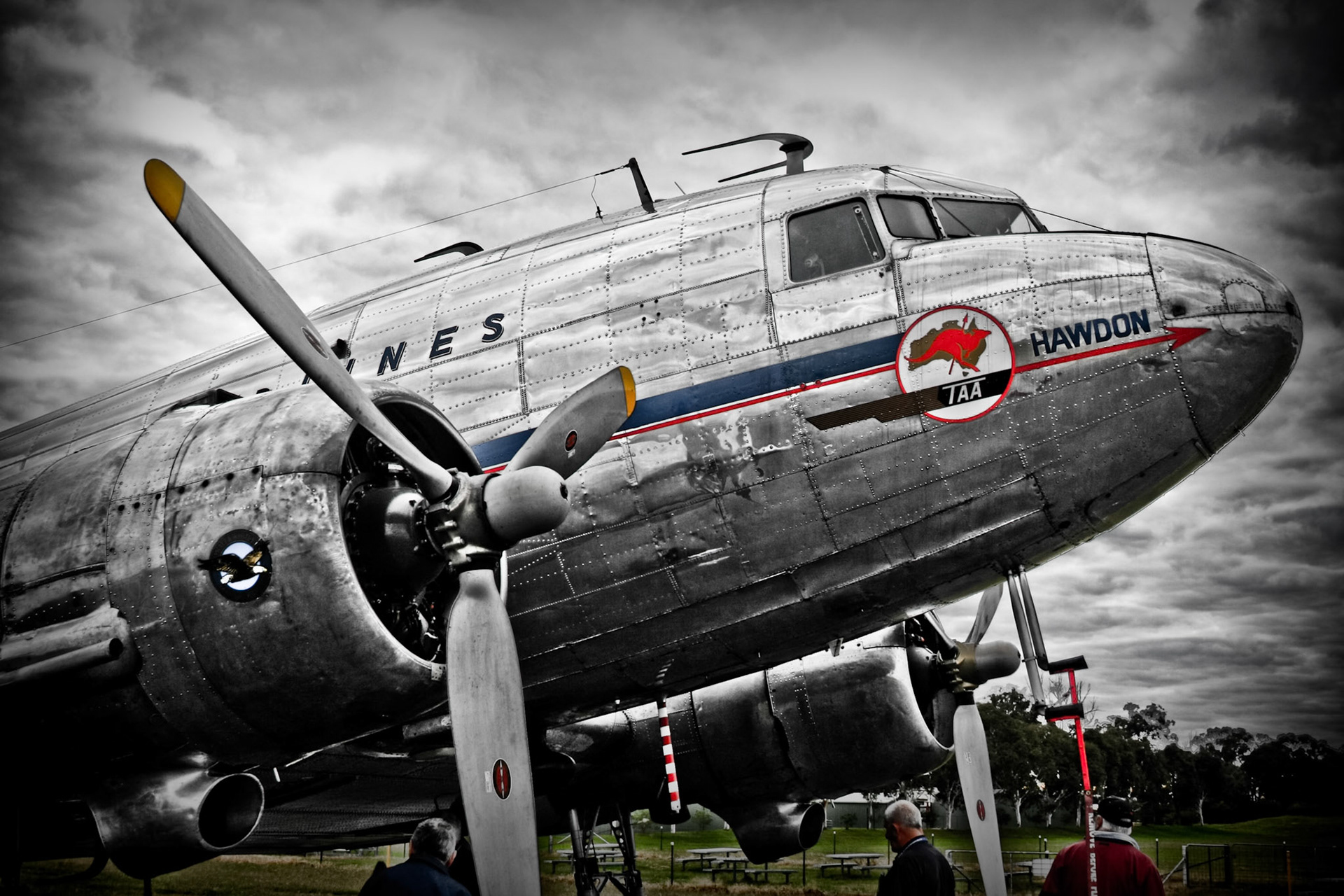 A detailed close-up of a vintage propeller airplane with "TAA" and "HAWDON" visible on its fuselage.
