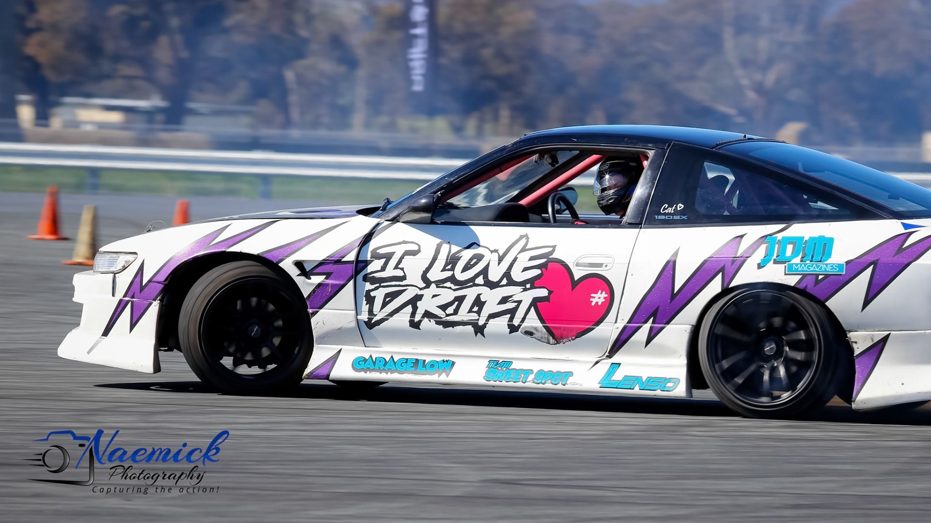 A white drift car with purple lightning bolt decals and "I LOVE DRIFT" graphic, on a track in Victoria, Australia.