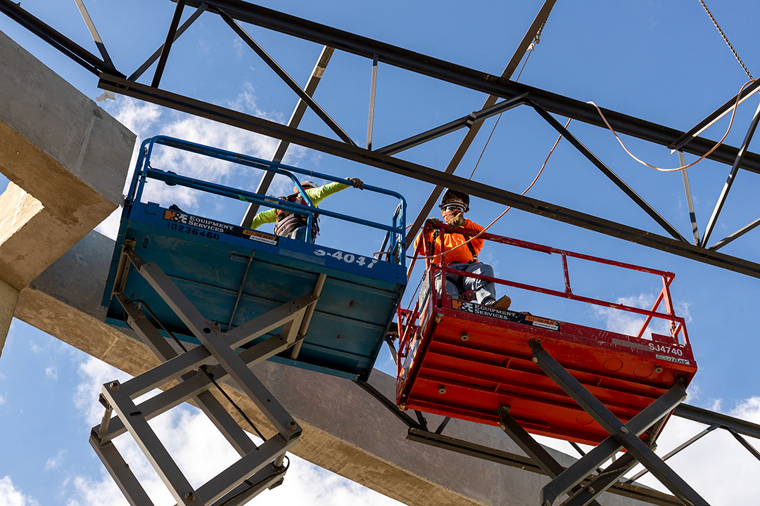 Construction workers wait on top of scissor lifts at the NBISD construction site on March 27, 2024. BLAINE YOUNG | Herald-Zeitung
