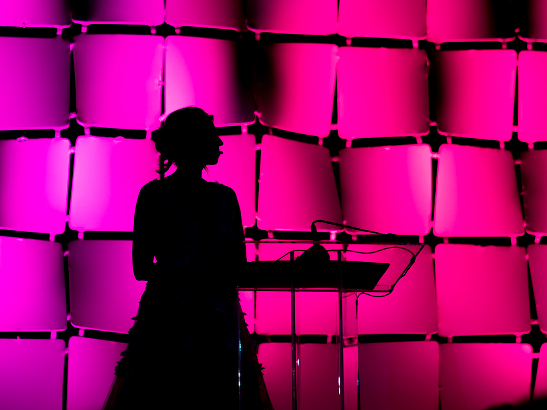 Bras for a Cause host Tiffany Mayne watches one of the honoree videos at the New Braunfels Civic/Convention Center on Oct. 3, 2024. BLAINE YOUNG | Herald-Zeitung