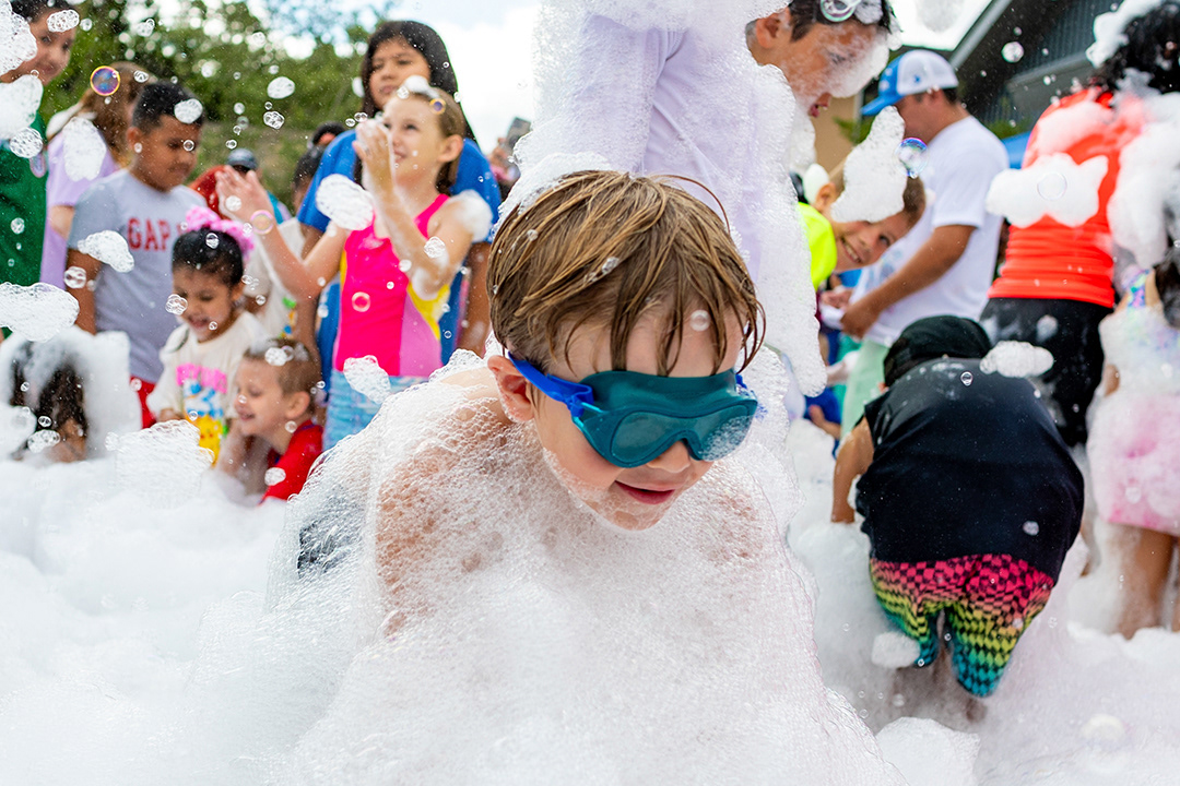 Cannon Jurgagtis, 7, wades through foam during the Mammen Family Public Library's Foam Party on June 26, 2024. BLAINE YOUNG | Herald-Zeitung