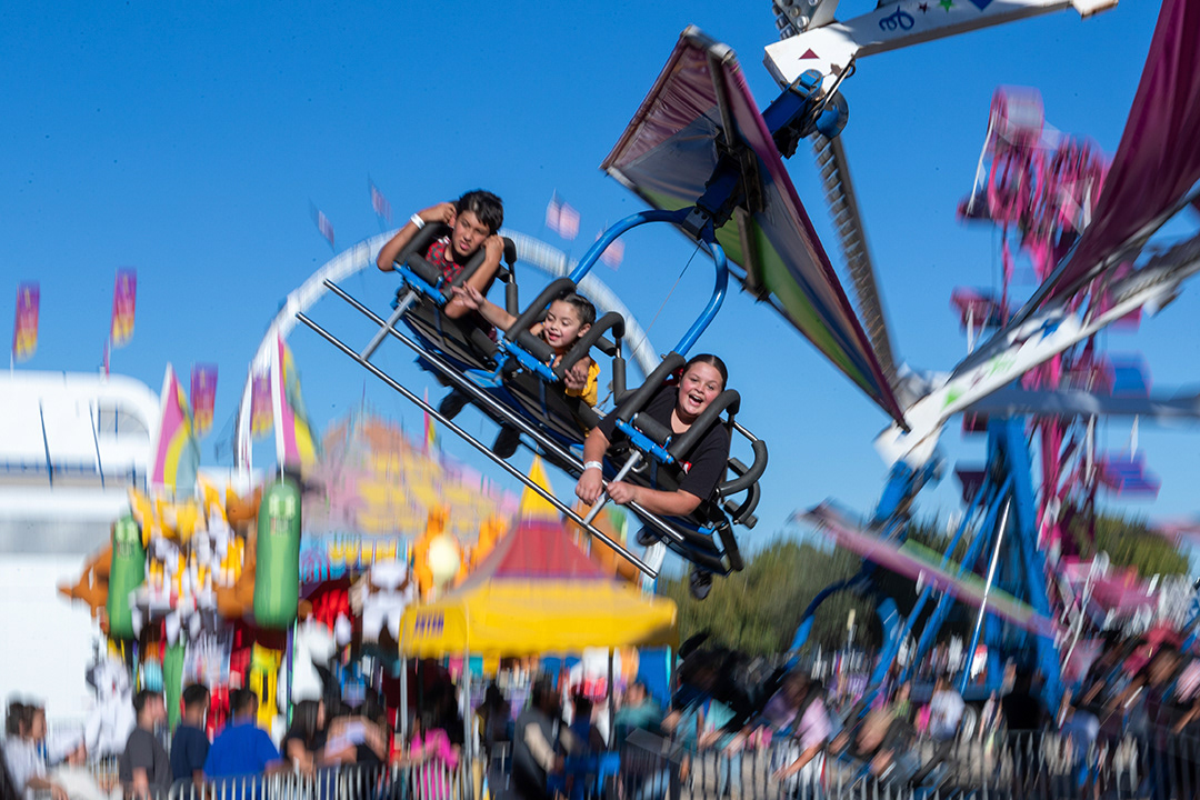 (From left) Gael Leon, 11, Benthly Nichols, 6, and Bella Nichols, 12, ride the Cliff Hanger at the Comal County Fair on Sept. 24, 2024. BLAINE YOUNG | Herald-Zeitung